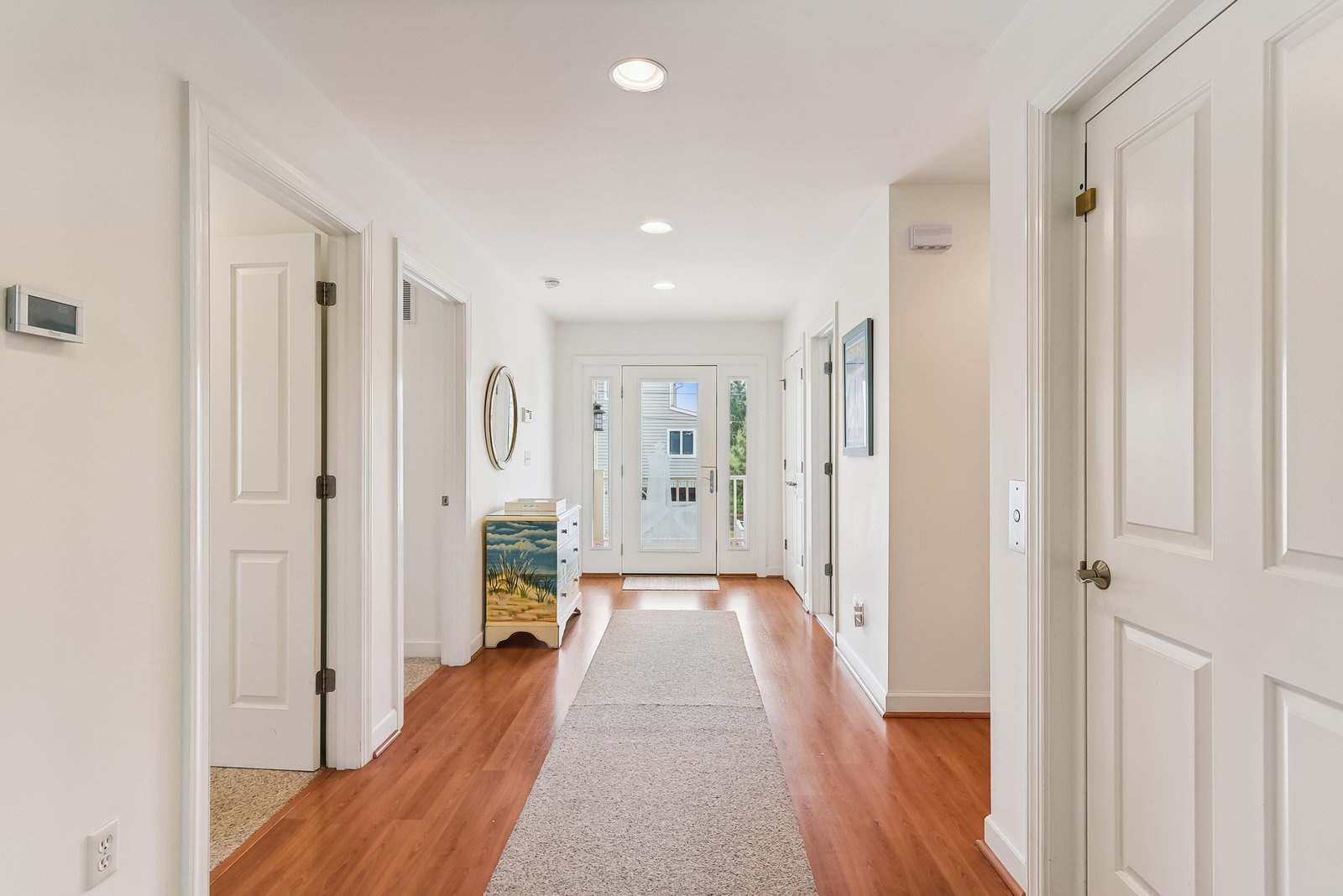Step into your bright, welcoming hallway with warm hardwood floors and a soft runner that leads you toward your own private entrance. Clean lines and coastal touches make you feel right at home from the moment you arrive.