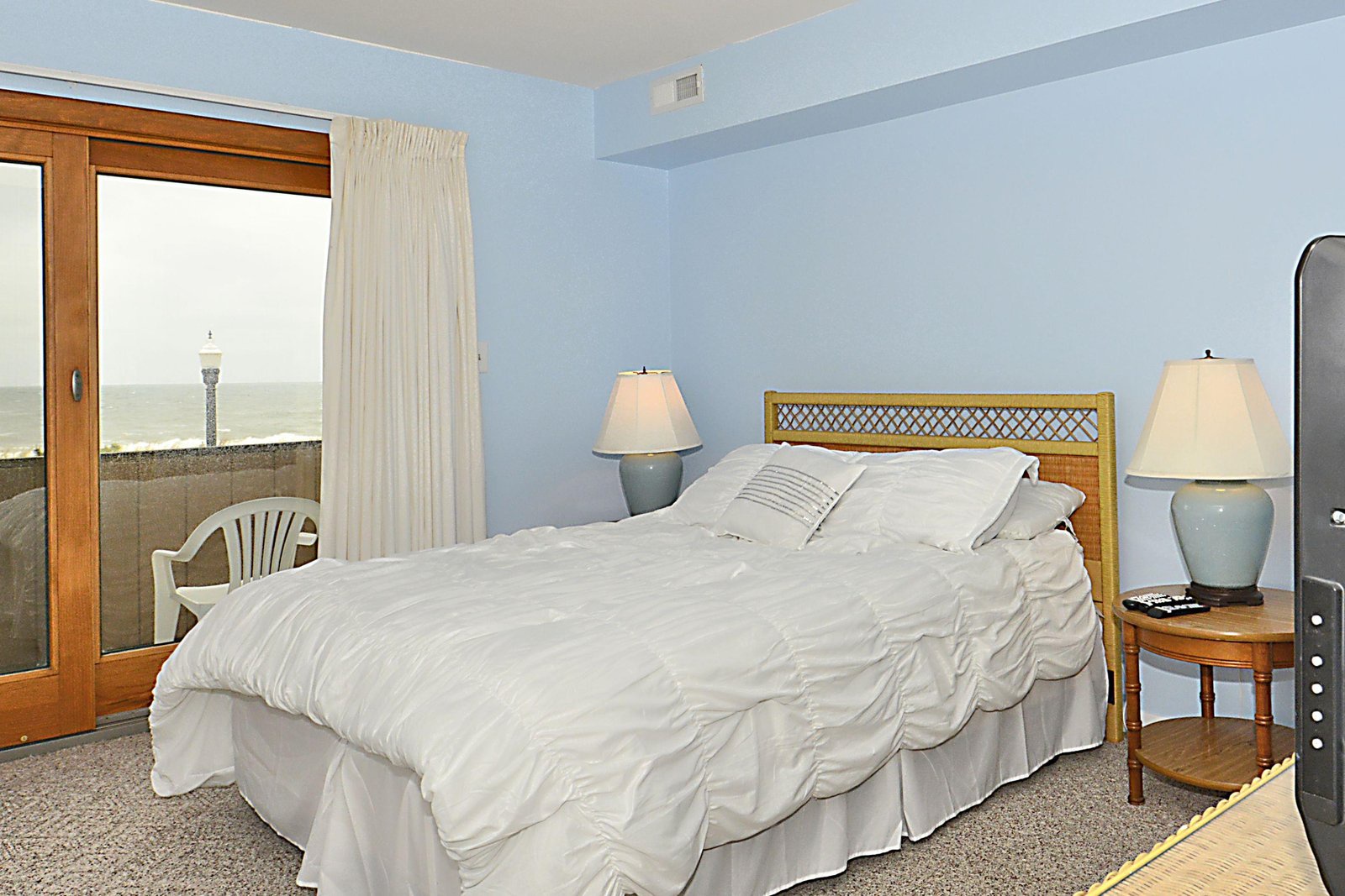 Your serene coastal bedroom opens to a private balcony with direct ocean views. Relax in the soft blue tones, unwind under calming lamplight, and drift to sleep with the sound of waves just beyond your door.