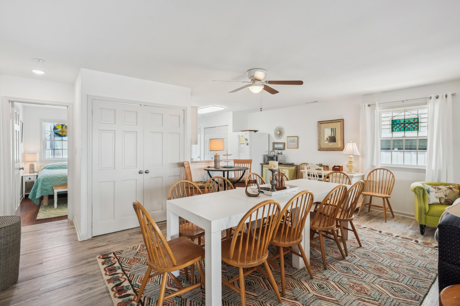 Gather around the spacious dining table for memorable meals together, with wood floors, warm lighting, and a cozy open layout that connects you to the full kitchen and living areas.