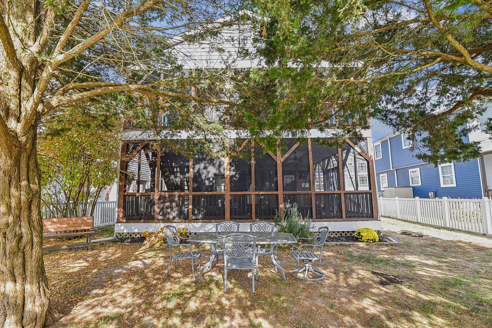 Private backyard retreat with shaded dining and enclosed screened porch perfect for outdoor living and memorable gatherings.