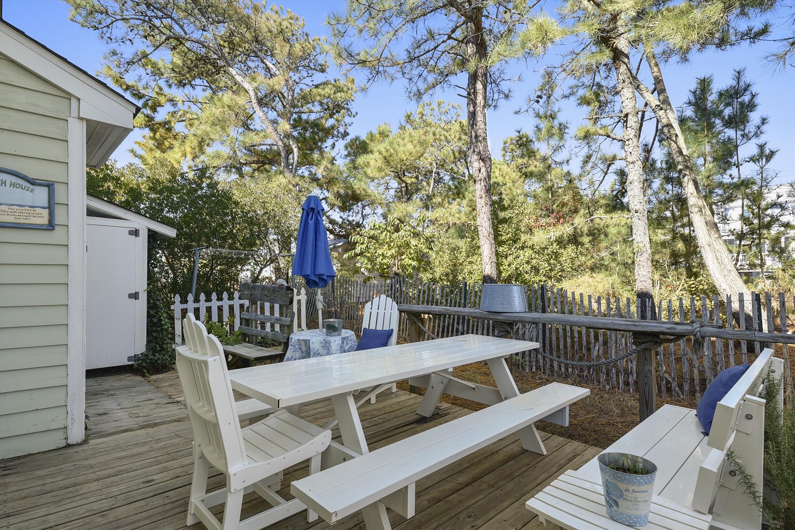 Enjoy your morning coffee or an alfresco meal at this sunny wooden deck surrounded by tall pines. A picnic table and cozy seating invite you to relax outdoors in nature's embrace.