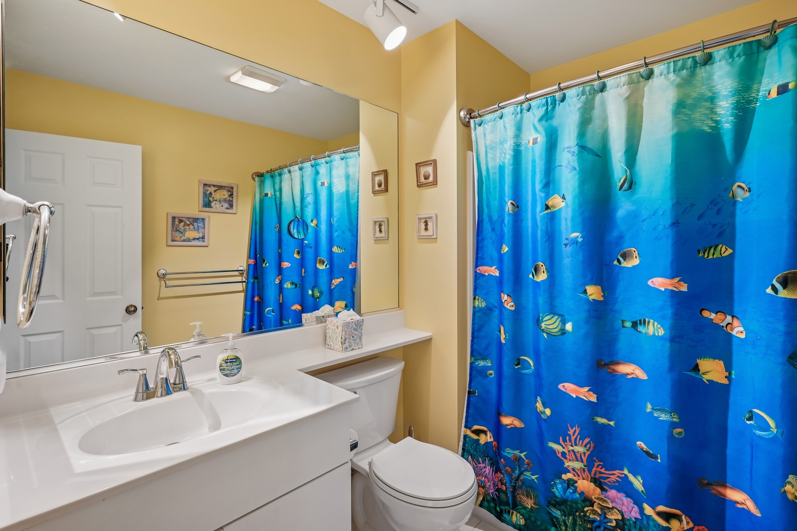 Dive into your morning routine in this bright bathroom featuring a vibrant underwater-themed shower curtain that transforms your daily ritual into an ocean adventure.
