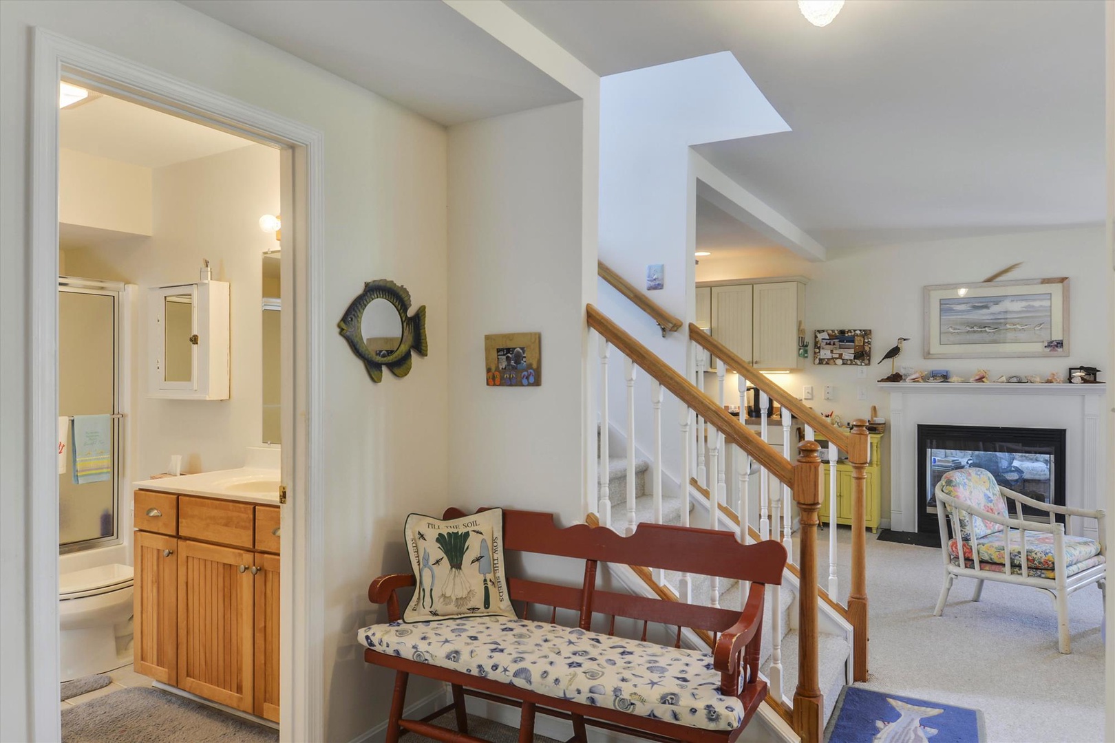 Warm coastal charm welcomes you from the moment you arrive. Relax on the cushioned bench, feel the soft carpet underfoot, and enjoy the inviting glow of the fireplace in the open living space ahead.