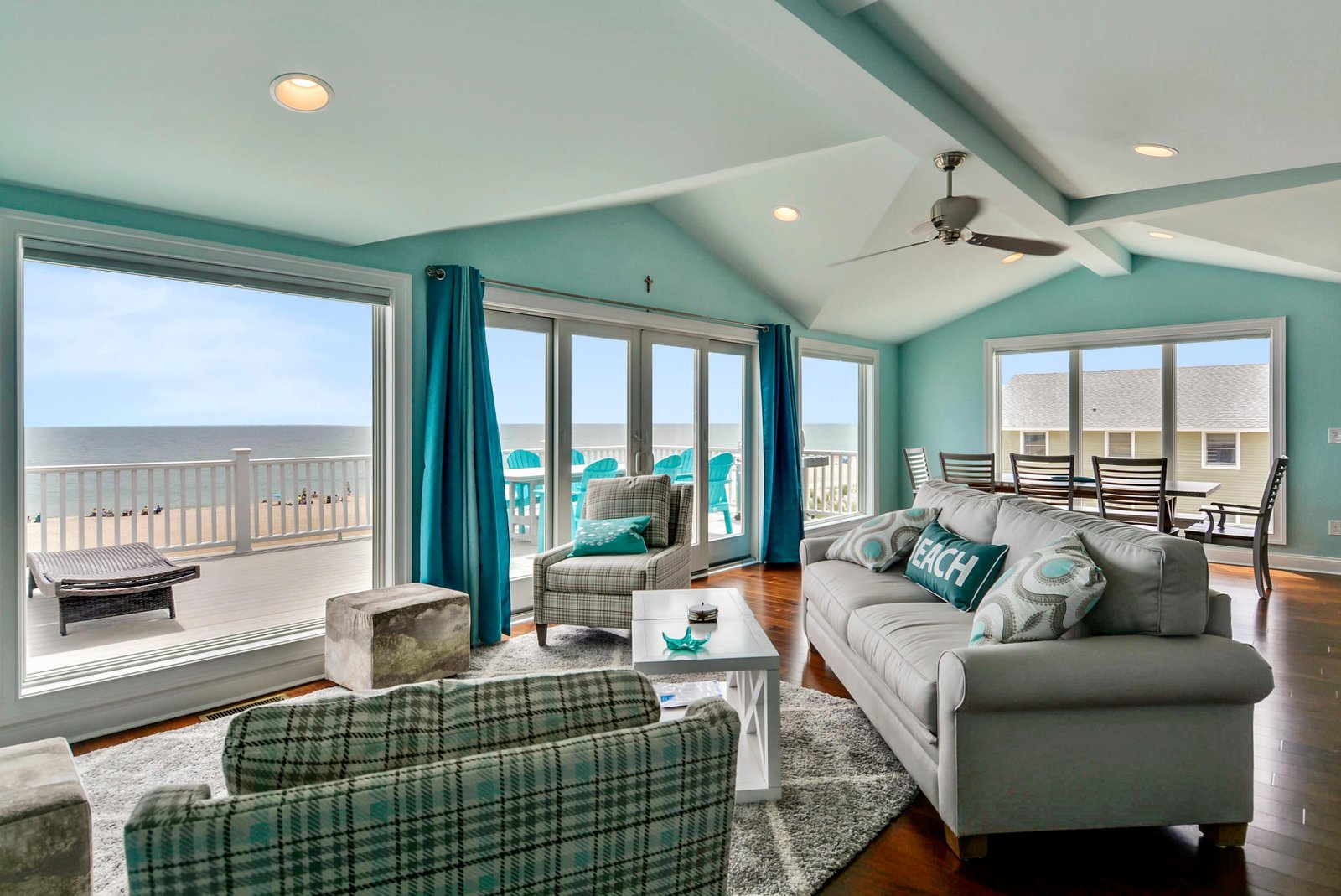 Unwind in this bright coastal living room where turquoise walls and sweeping ocean views create your perfect beach getaway. Step outside to your private deck and feel the sea breeze as you relax.