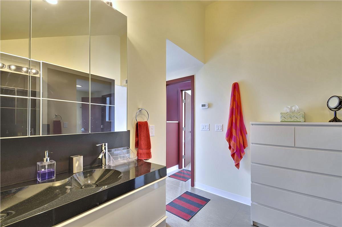 A spacious bathroom with sleek countertops and modern fixtures awaits, offering you a stylish space to refresh and unwind during your stay.