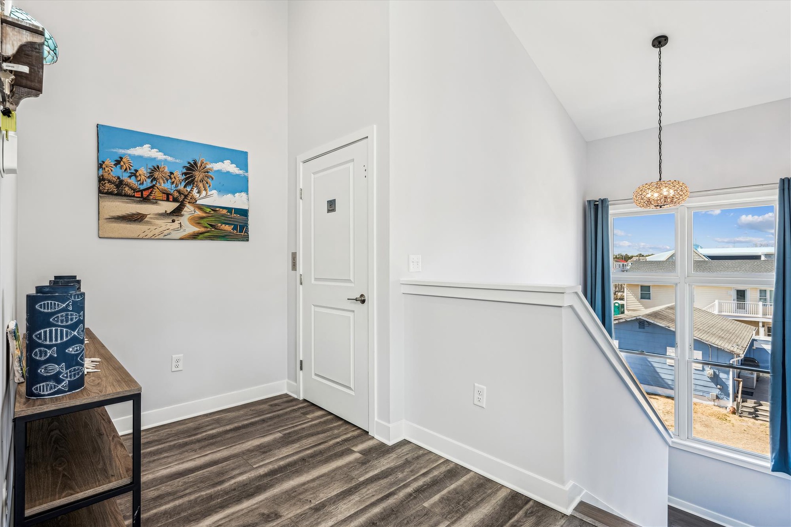 Your bright hallway features warm coastal art and leads to your private balcony with beautiful views of the surrounding area.