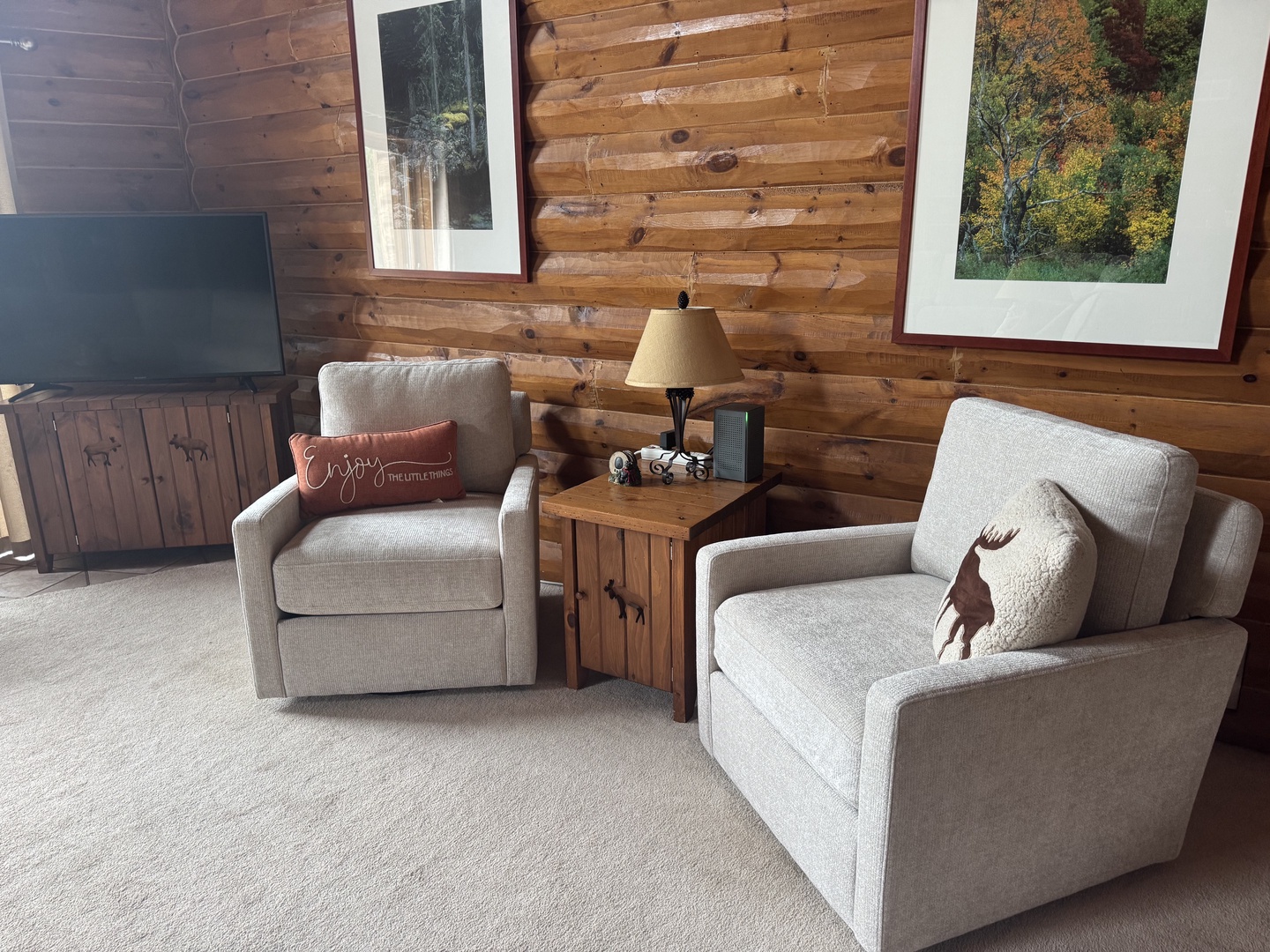 Sink into plush armchairs in your cozy living area, where rustic log cabin walls and mountain-inspired décor create the perfect retreat after a day of adventure.