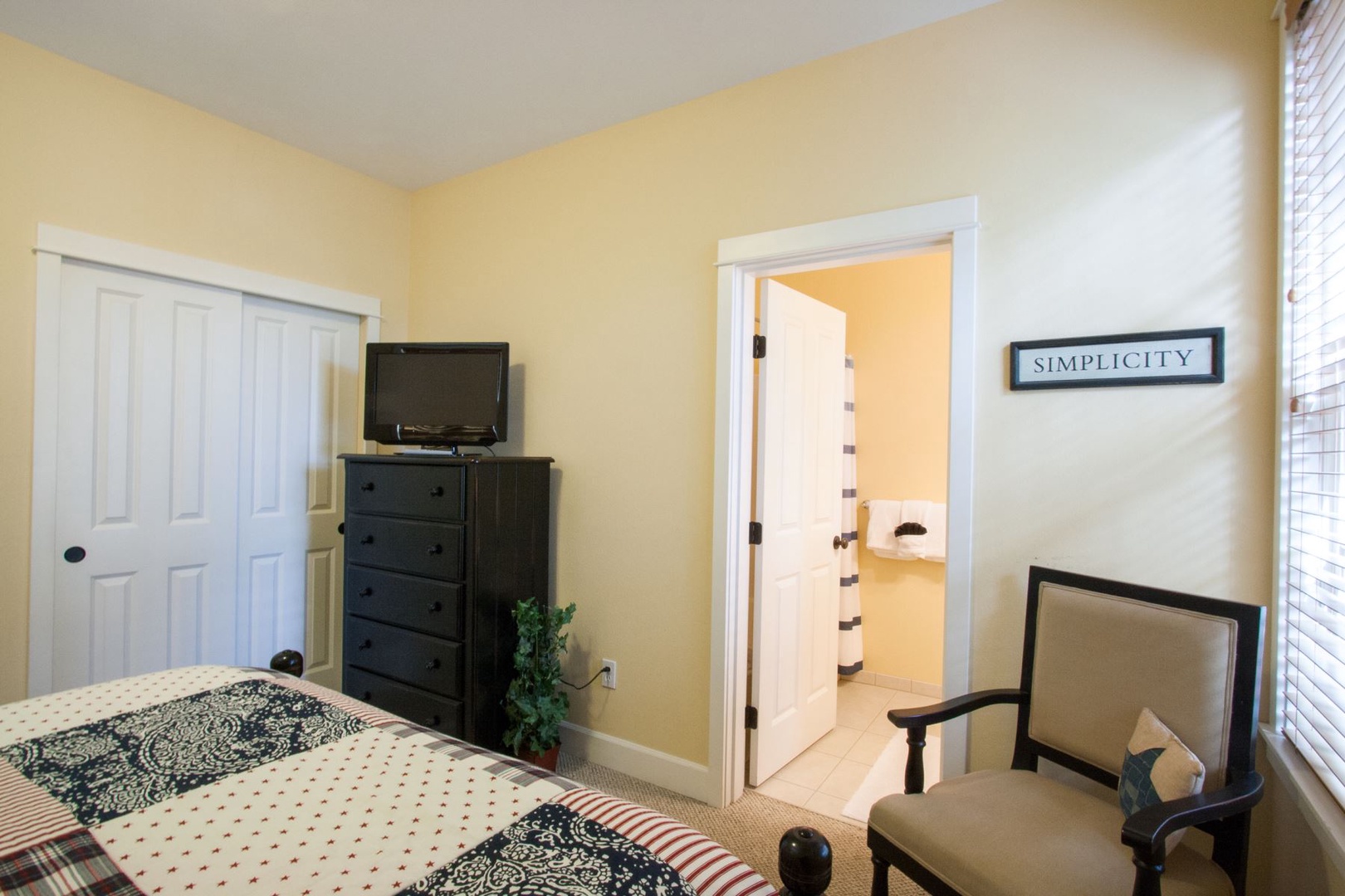 Primary suite includes a full bath, luxurious bedding and flat screen tv