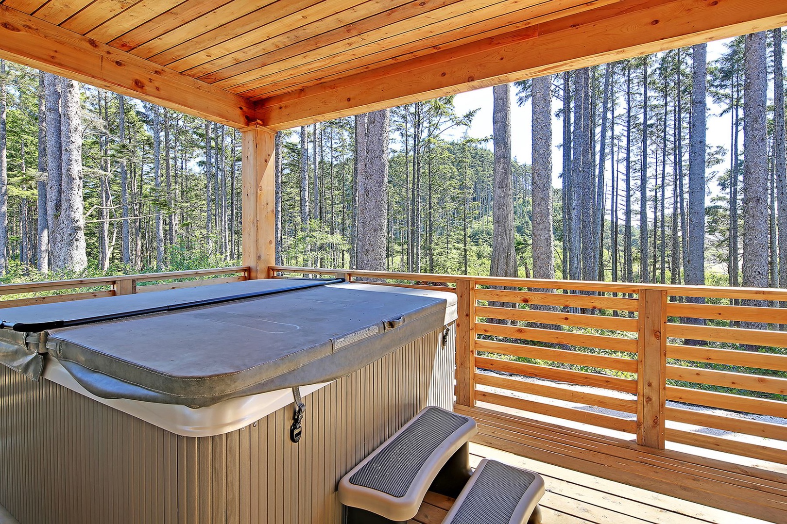 Covered deck with hot tub and ocean views