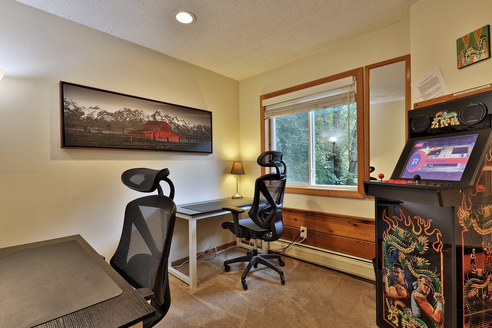 Office on the main floor with two desks and classic arcade console