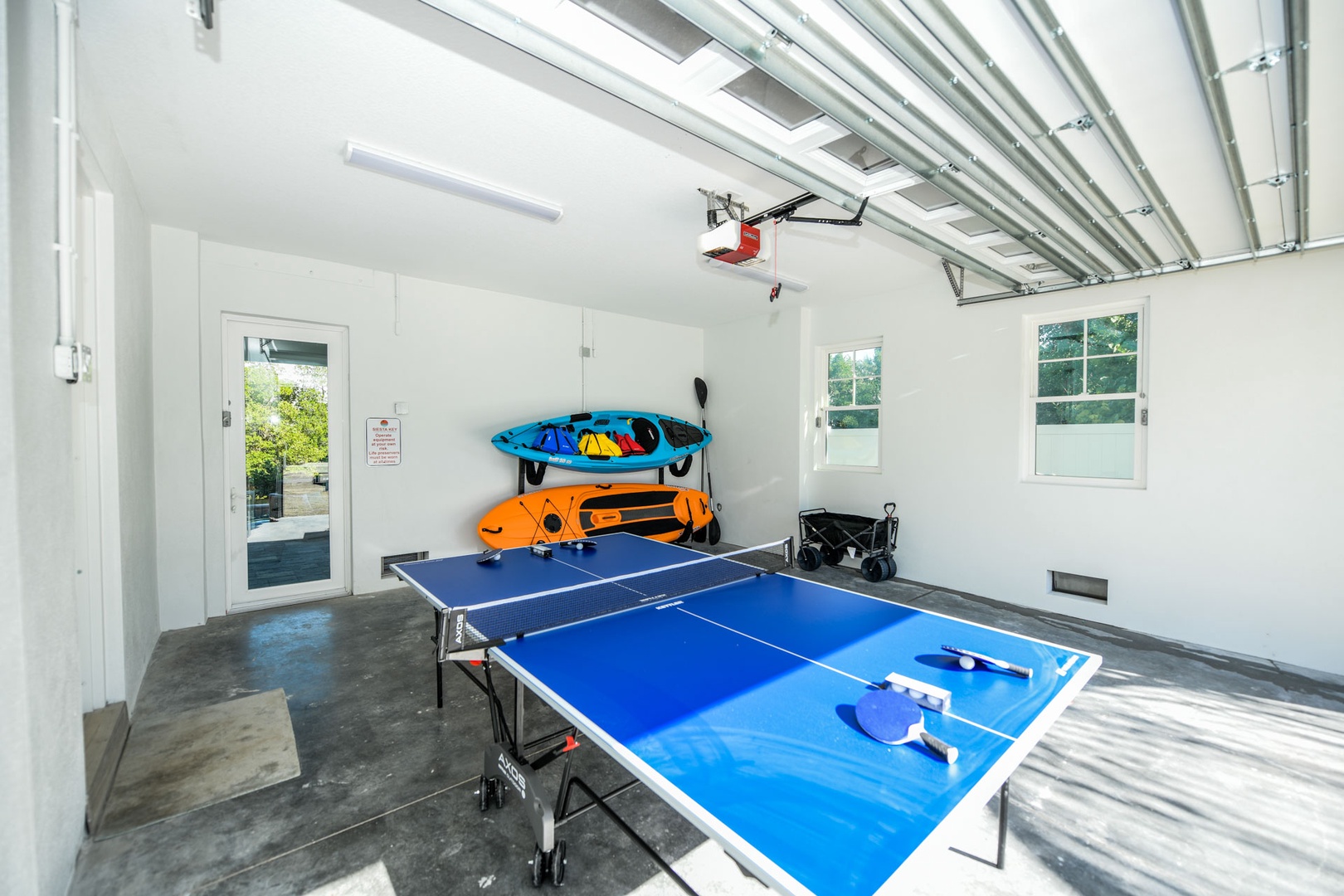 Garage area w/ ping pong table, kayak, and paddleboard