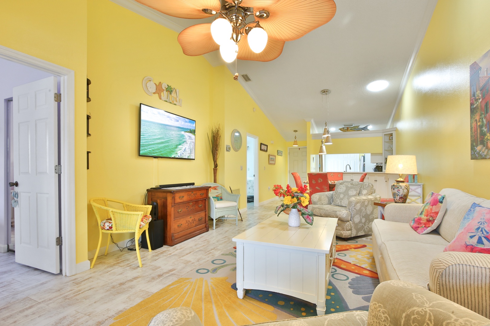 Step into your bright, beachy escape where sunny yellow walls and coastal decor instantly lift your spirits. Relax on comfortable seating, enjoy ocean breezes from the ceiling fan, and cook meals in your open kitchen—all in this cheerful, welcoming retrea