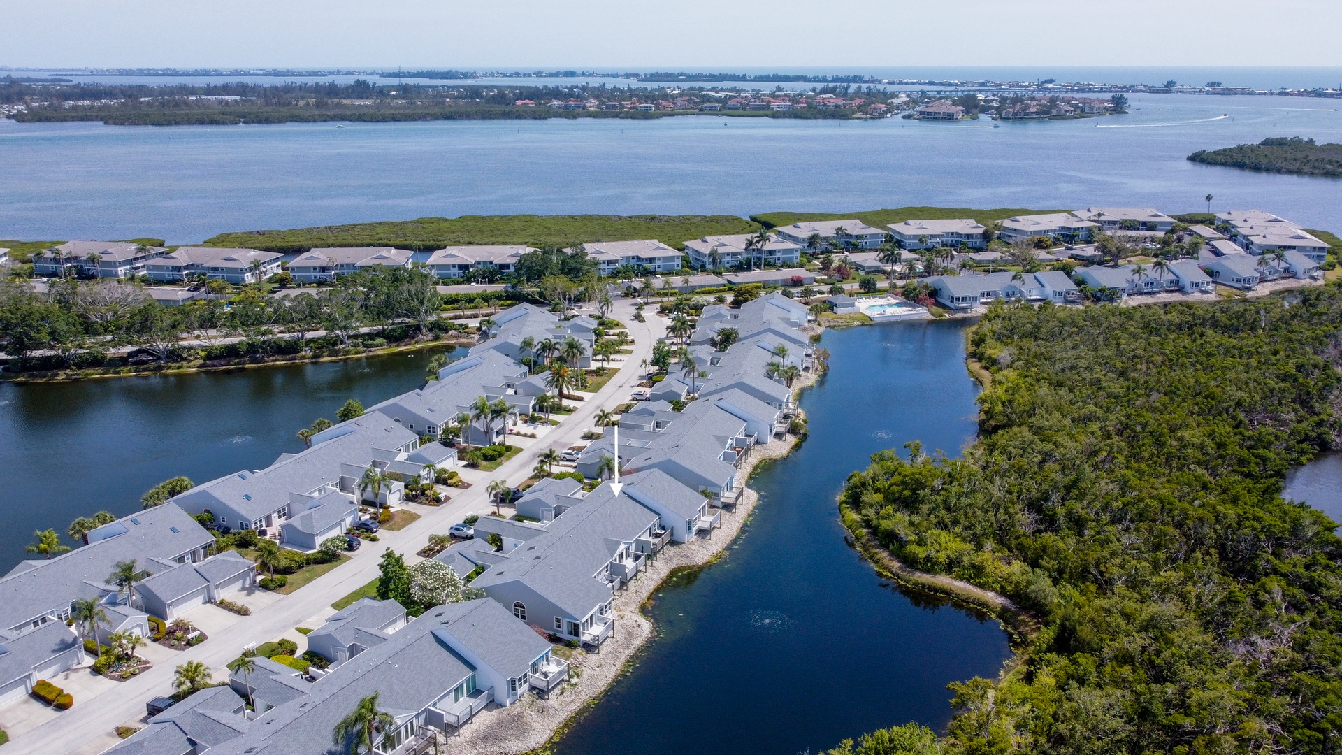 Aerial view of a waterfront vacation rental community nestled between serene inland lakes and lush natural preserves, offering coastal Florida living.