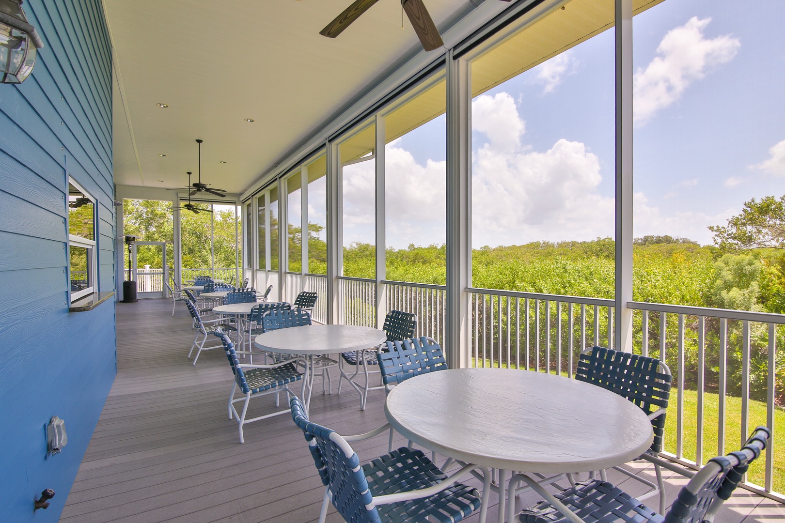 Relax on your screened porch with sweeping views of lush greenery. Comfortable seating and ceiling fans invite you to unwind, enjoy fresh air, and take in peaceful natural surroundings.