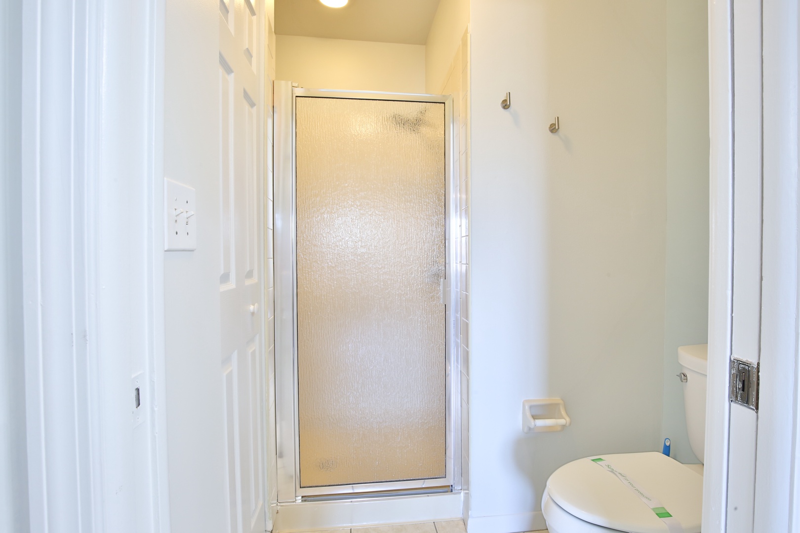 Your private bathroom features a refreshing shower with frosted glass doors for privacy and bright, clean finishes.