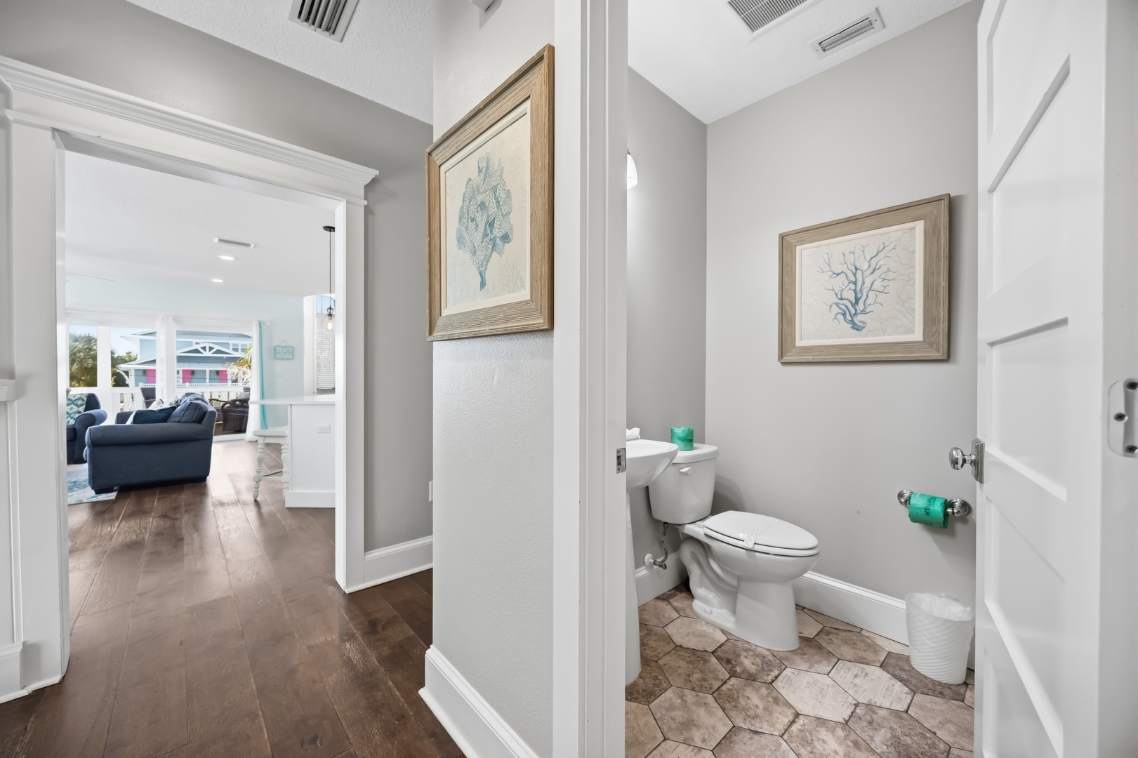 Step into your private powder room featuring coastal artwork and modern fixtures for your comfort.