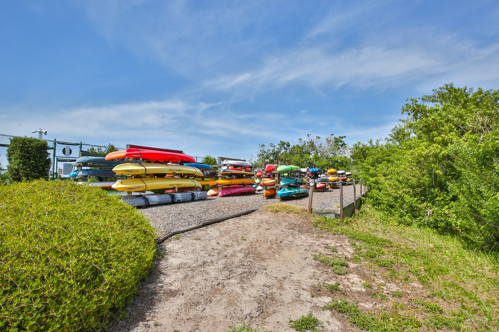 Colorful kayaks and canoes stacked at a waterfront storage area, ready for guests to explore nearby waterways and enjoy paddling adventures.