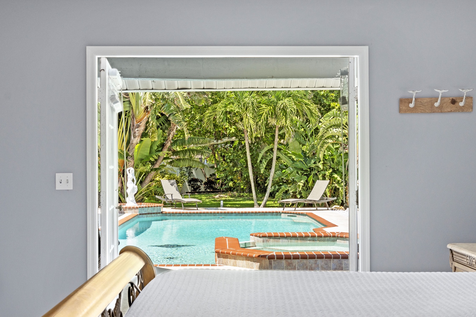 Step from your bedroom straight to your private oasis—a sparkling pool framed by lush tropical palms and sunshine, waiting for you to dive in.