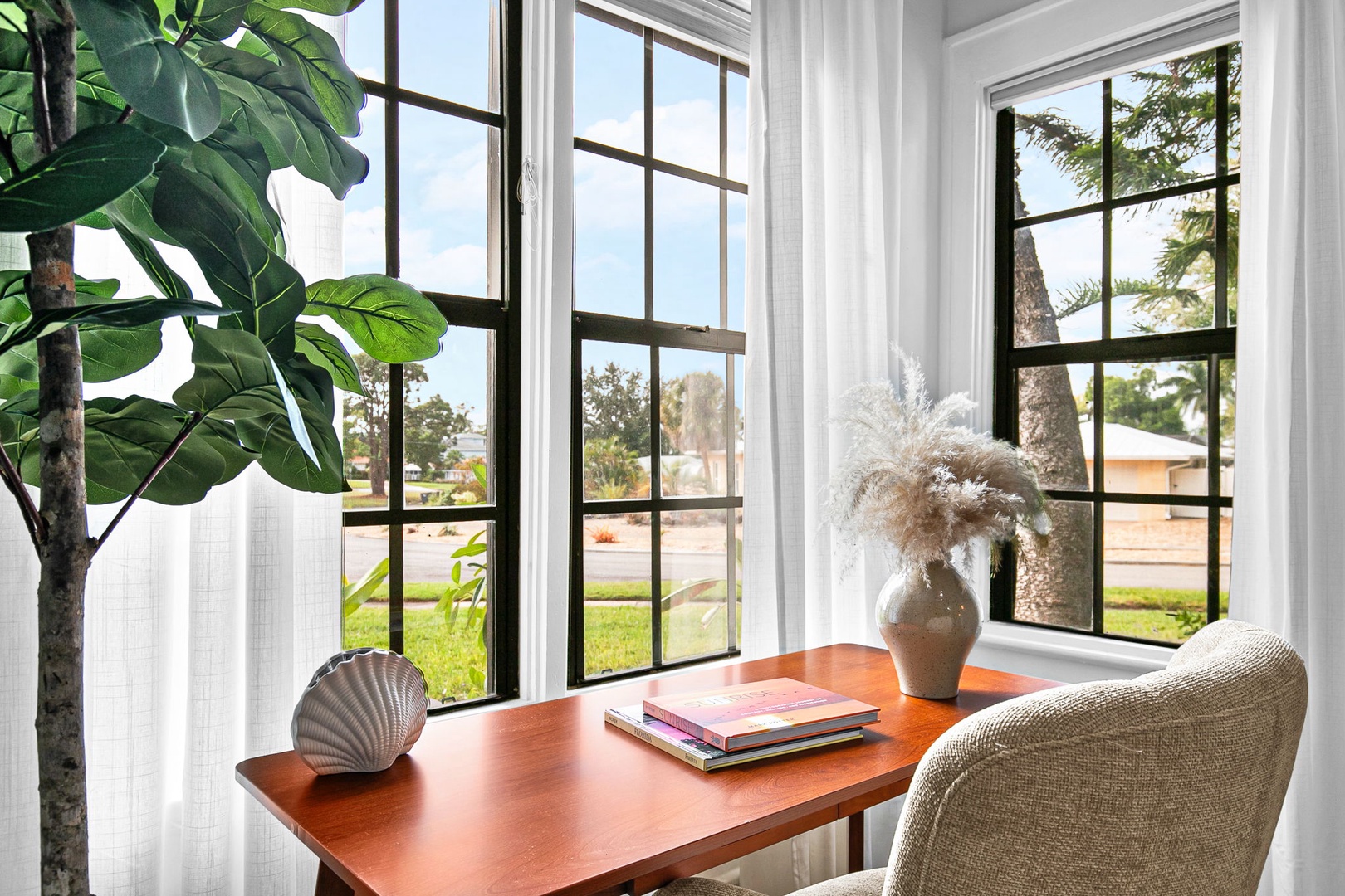 Your bright workspace overlooks peaceful palm trees, creating the perfect spot to catch up on reading or plan your next adventure.
