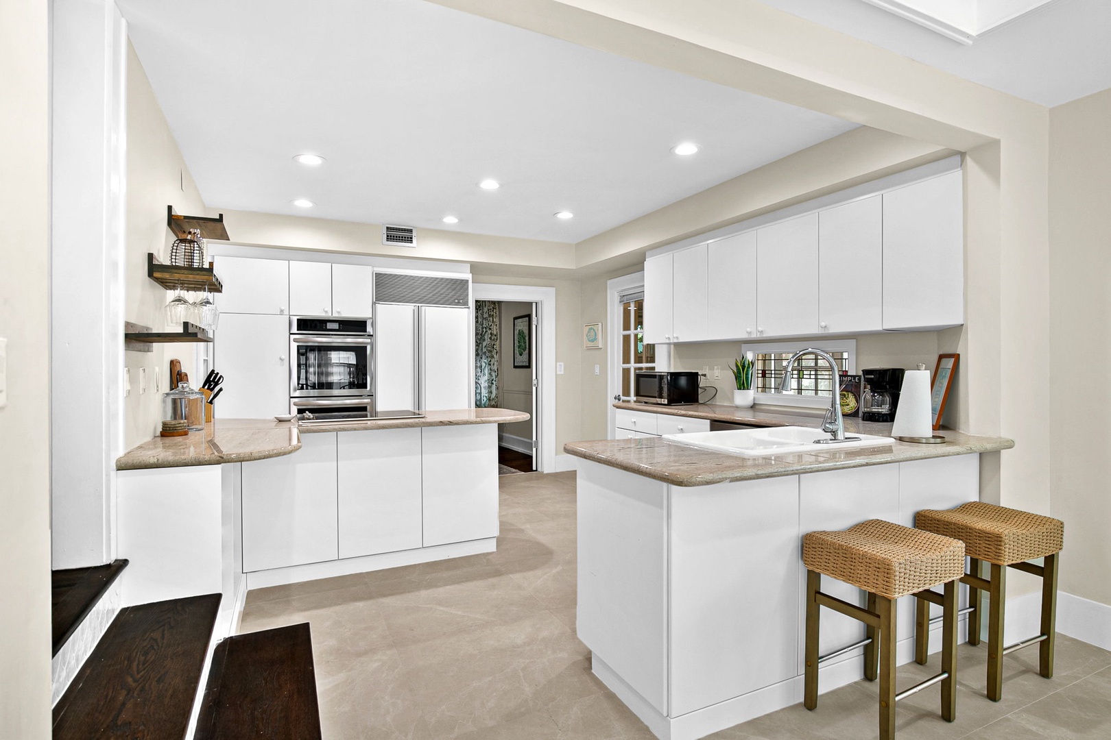 Your spacious modern kitchen features sleek white cabinets, granite countertops, and premium stainless appliances perfect for creating memorable meals during your stay.