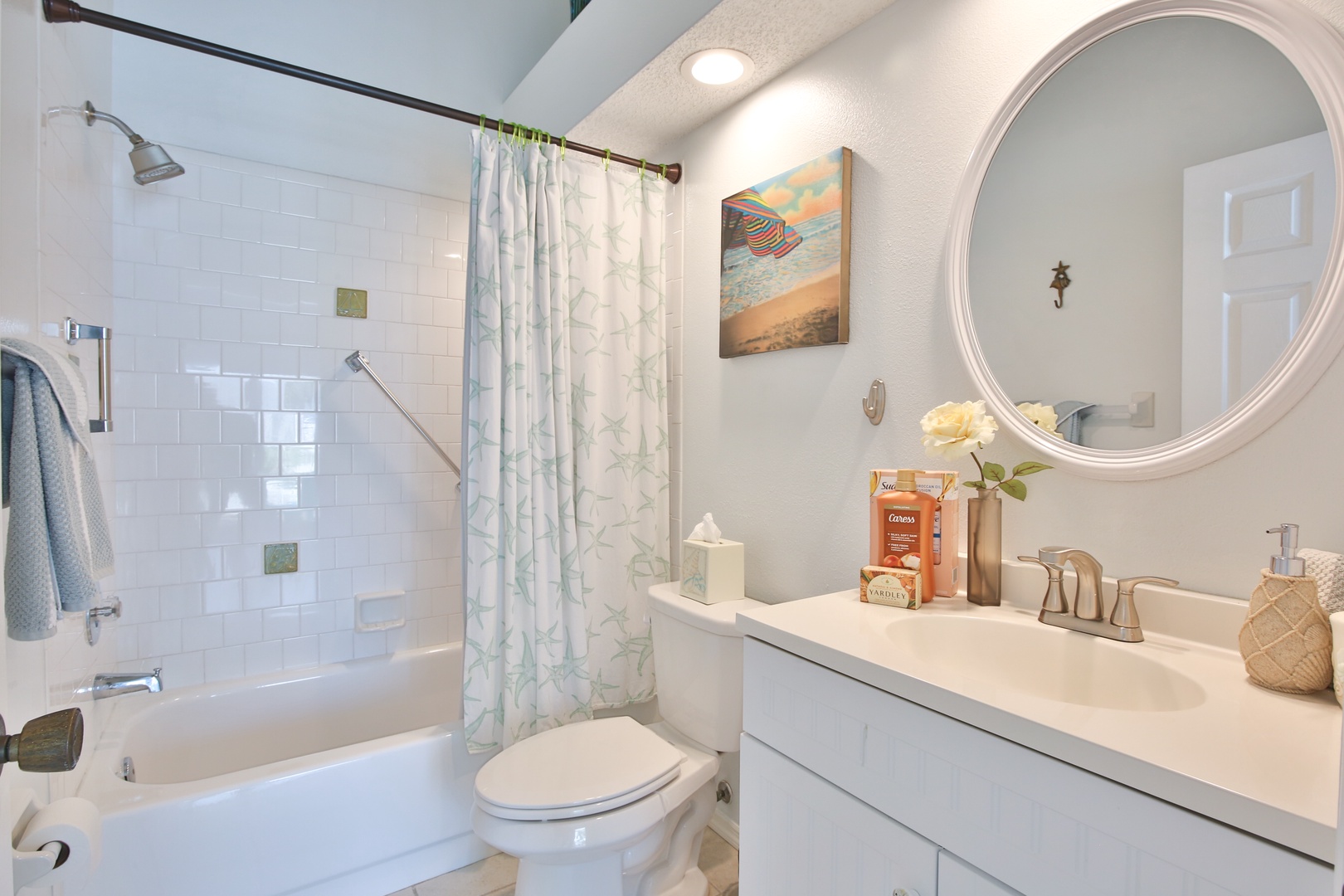 Freshen up in this coastal-inspired bathroom with a spacious tub-shower combo, soft linens, and beachy accents that set a relaxing, vacation-ready mood.