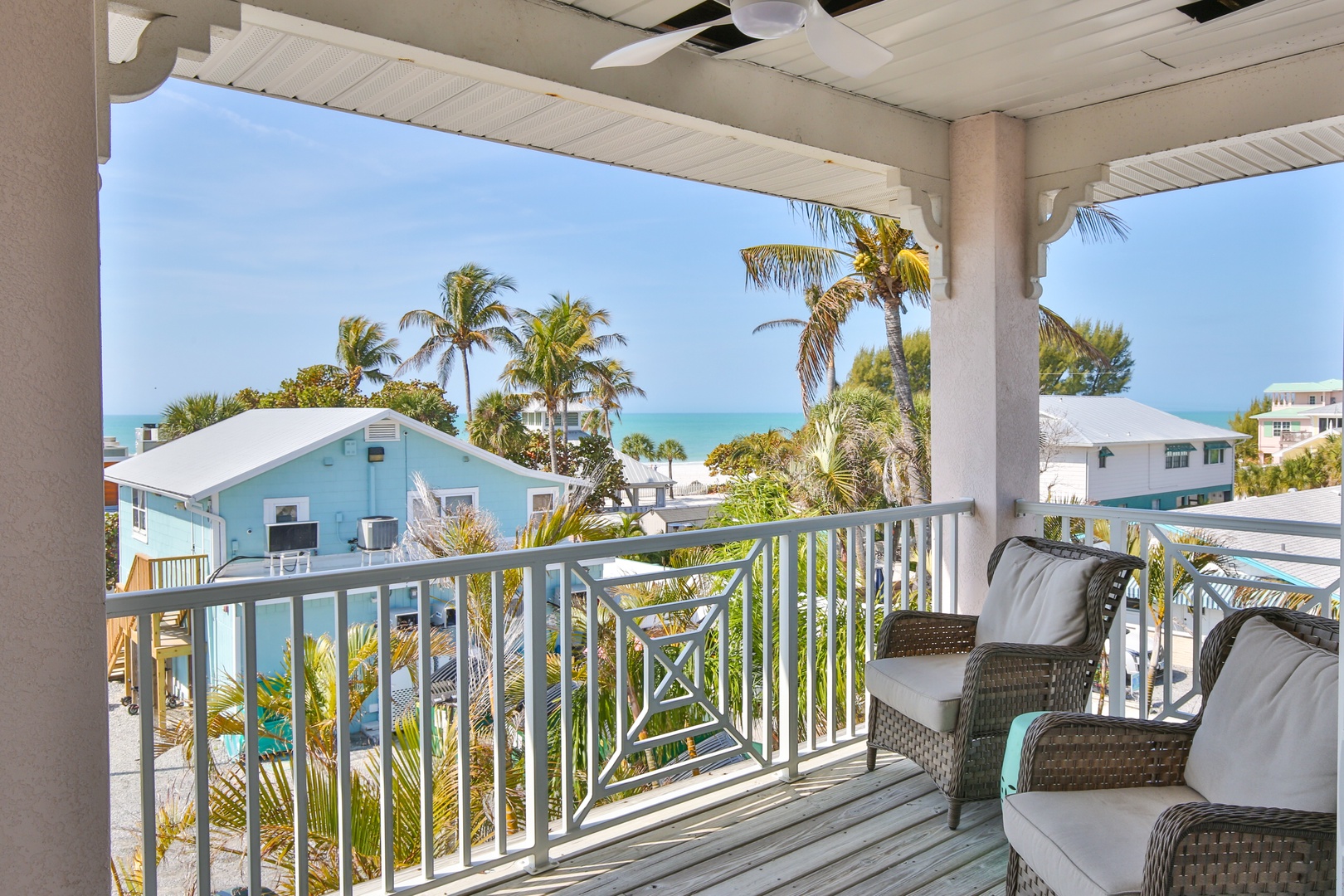 Relax on your private balcony with stunning ocean views, tropical palms swaying nearby, and comfortable seating to unwind.