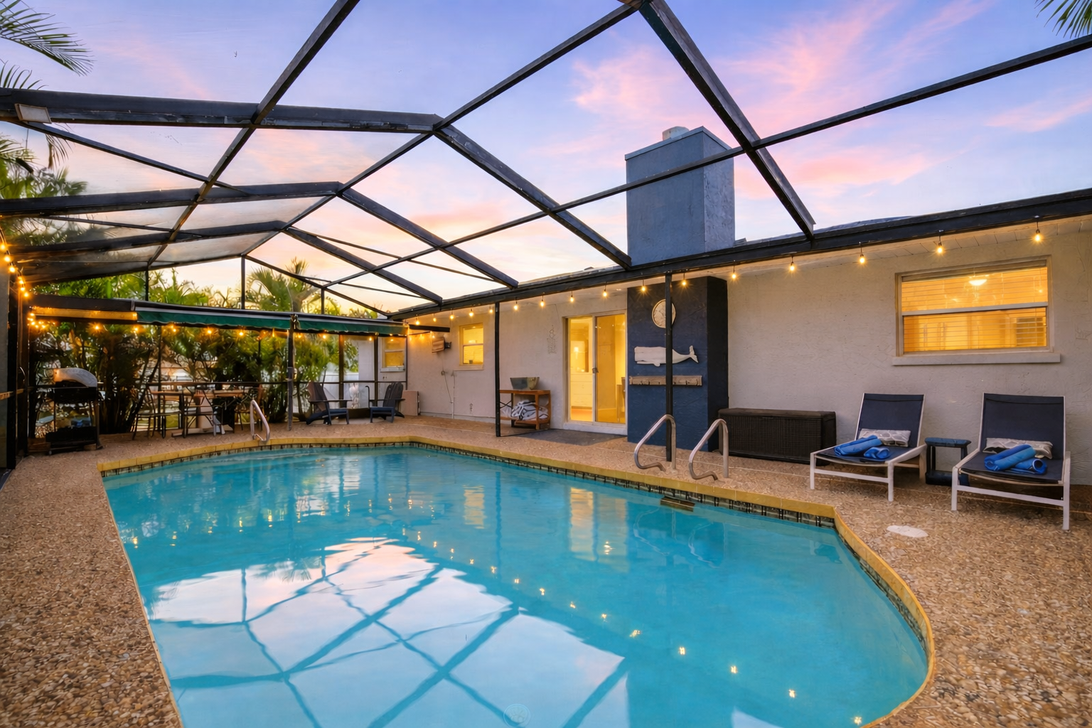 Dive into your private oasis where warm string lights create magical evening ambiance around the screened pool.