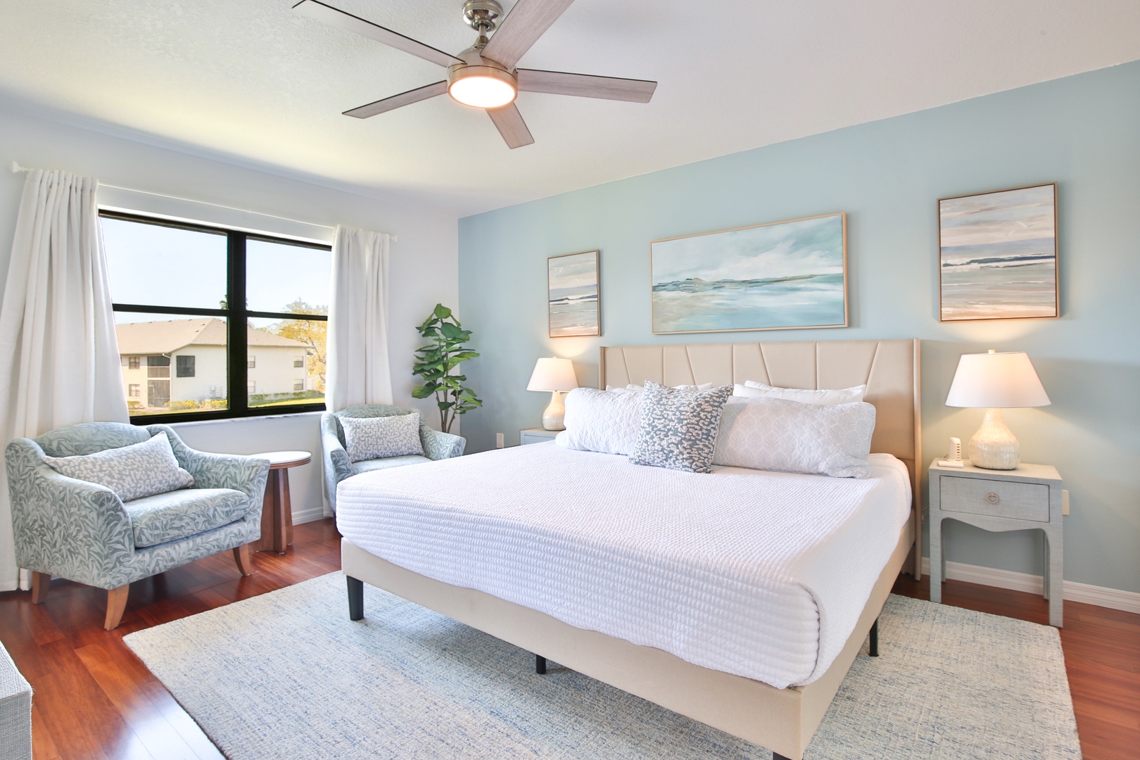 Drift into dreamland in your peaceful bedroom sanctuary with coastal artwork, plush bedding, and gentle ceiling fan breezes.