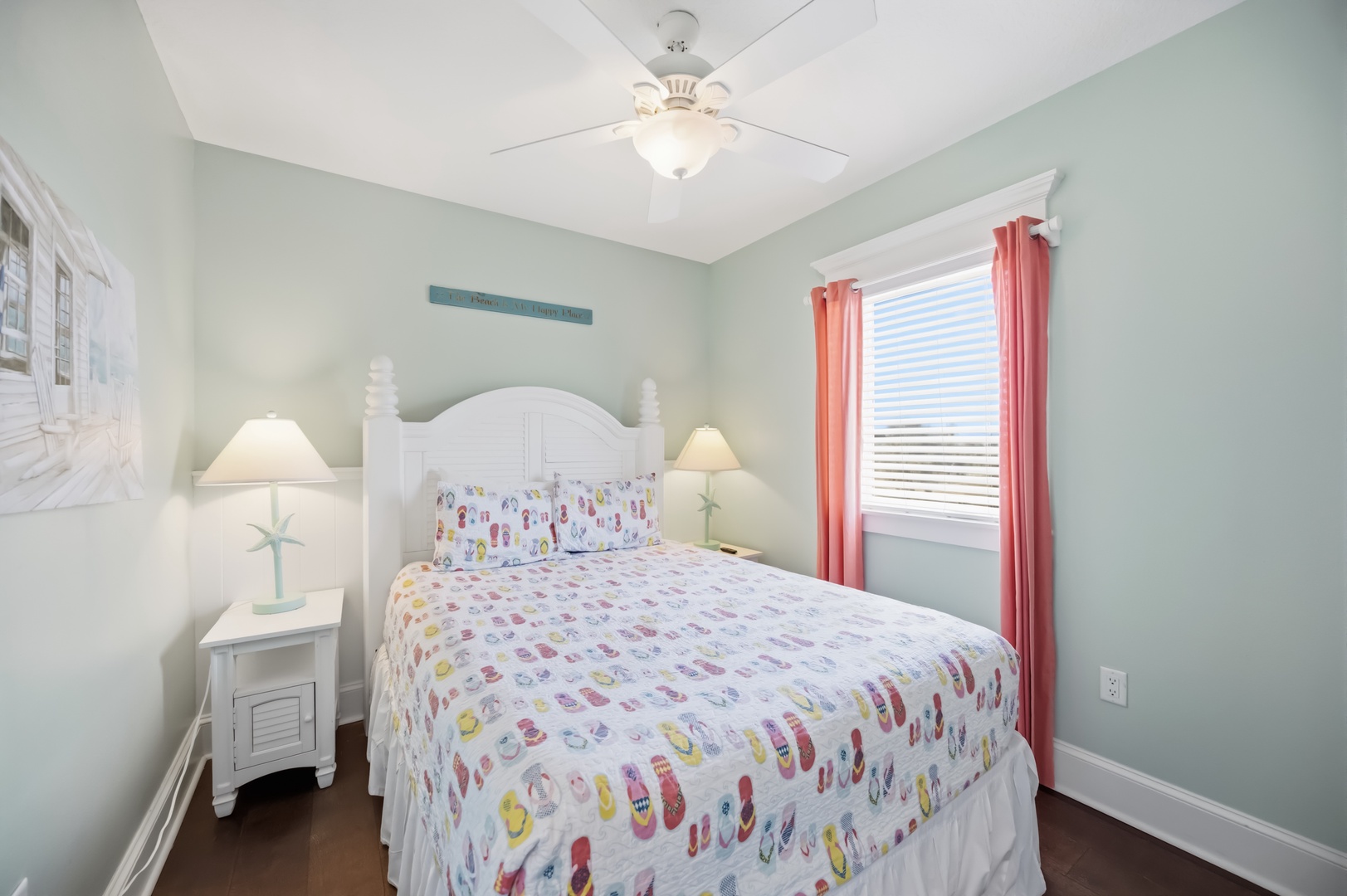 Drift off in this cheerful bedroom where soft mint walls and playful linens create your perfect coastal retreat.