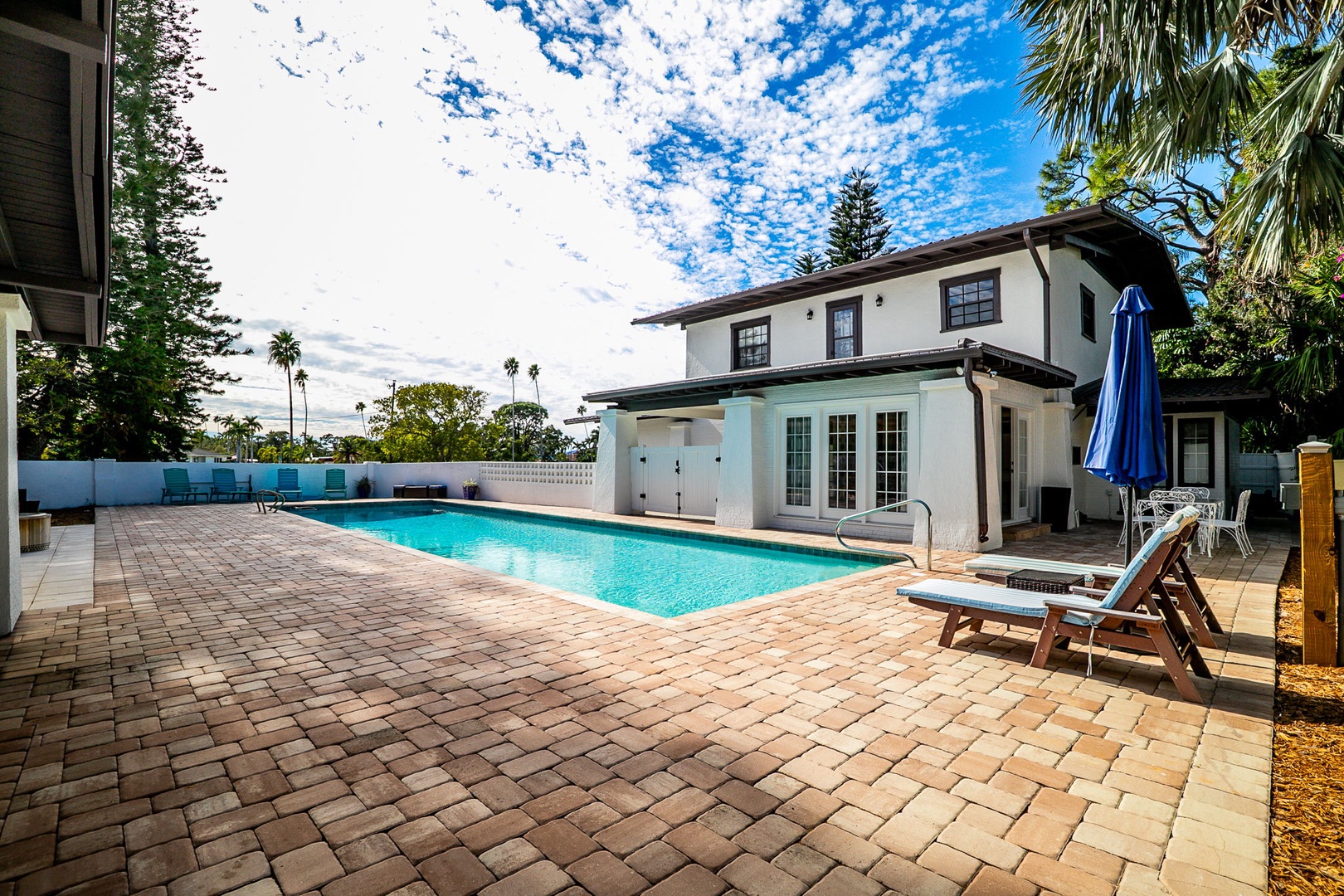 Step into your private oasis with a sparkling pool surrounded by tropical palms, perfect for soaking up Florida sunshine on comfortable loungers.