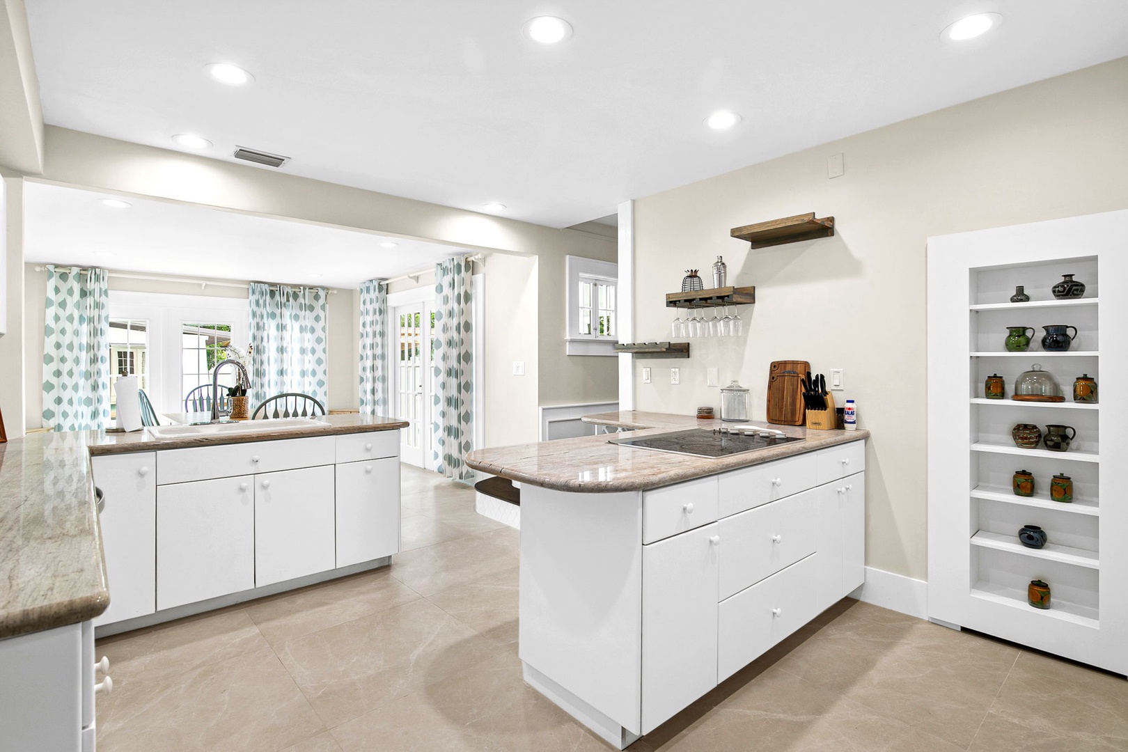 Your spacious kitchen awaits with modern appliances, granite countertops, and thoughtful touches like floating shelves and built-in display areas.