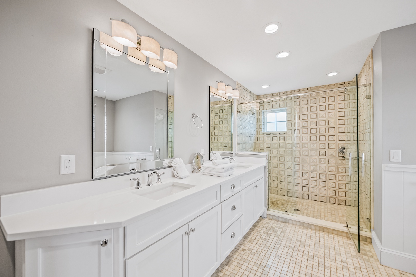 Pamper yourself in this spa-like master bathroom with dual vanities, luxurious walk-in shower, and elegant lighting for your ultimate relaxation.