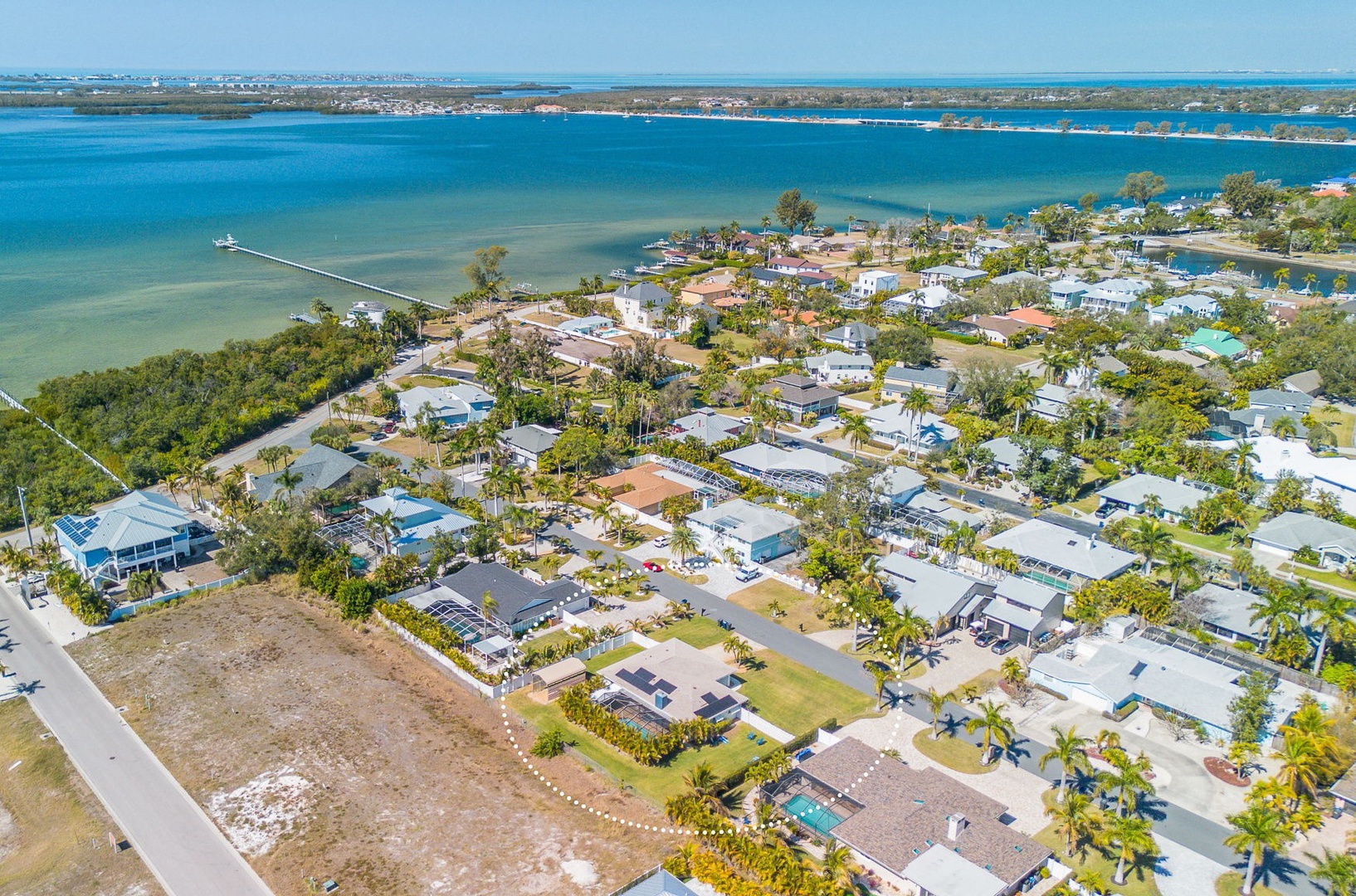 Aerial view of charming neighborhood with pristine bay views and manatee watching close by at Portosueno Park.