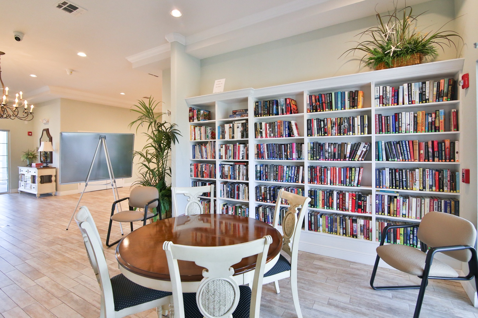 A well-stocked library invites you to settle in with your favorite book while sunlight streams through nearby windows, creating a peaceful communal retreat for reading and relaxation.