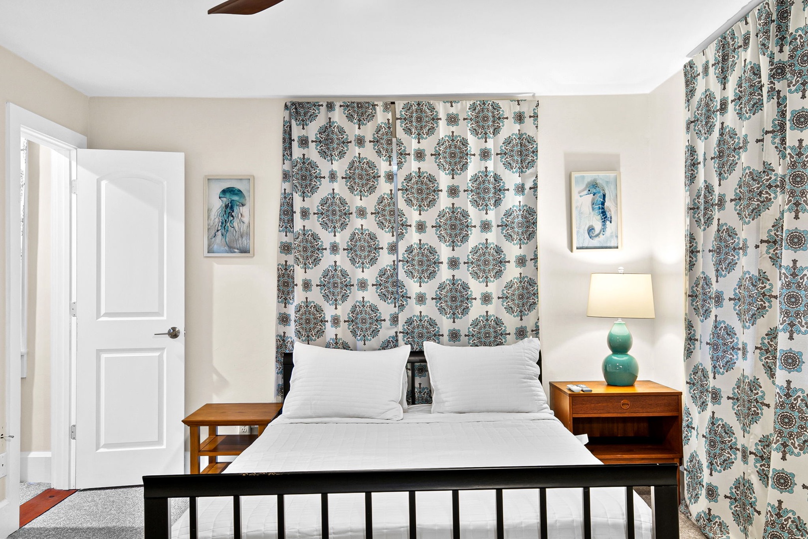 Your peaceful retreat features coastal-inspired decor with crisp white linens and charming nautical artwork creating a serene seaside atmosphere.