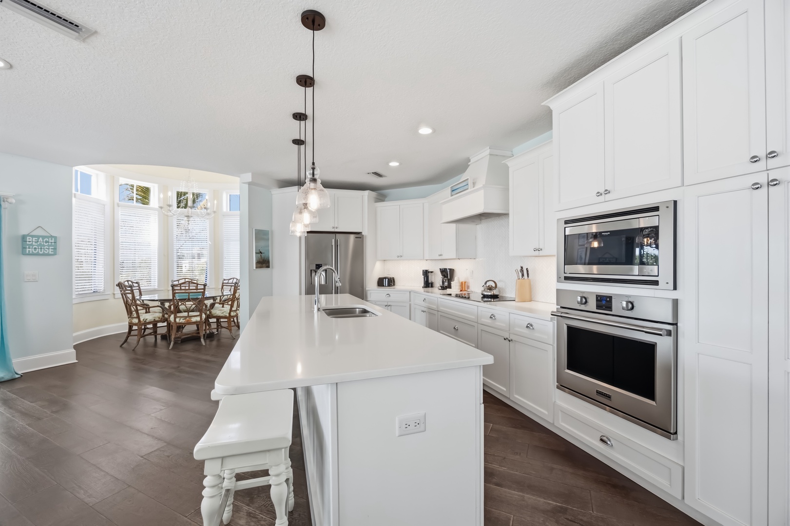 Your fully equipped kitchen features gleaming quartz counters, stainless appliances, and a bright dining nook perfect for morning coffee or family meals.