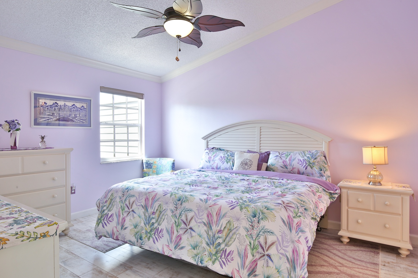 Drift off in your peaceful retreat, where soft pastels and tropical florals blend with bright natural light. Cool ceiling fan breezes and plush bedding promise restful nights.