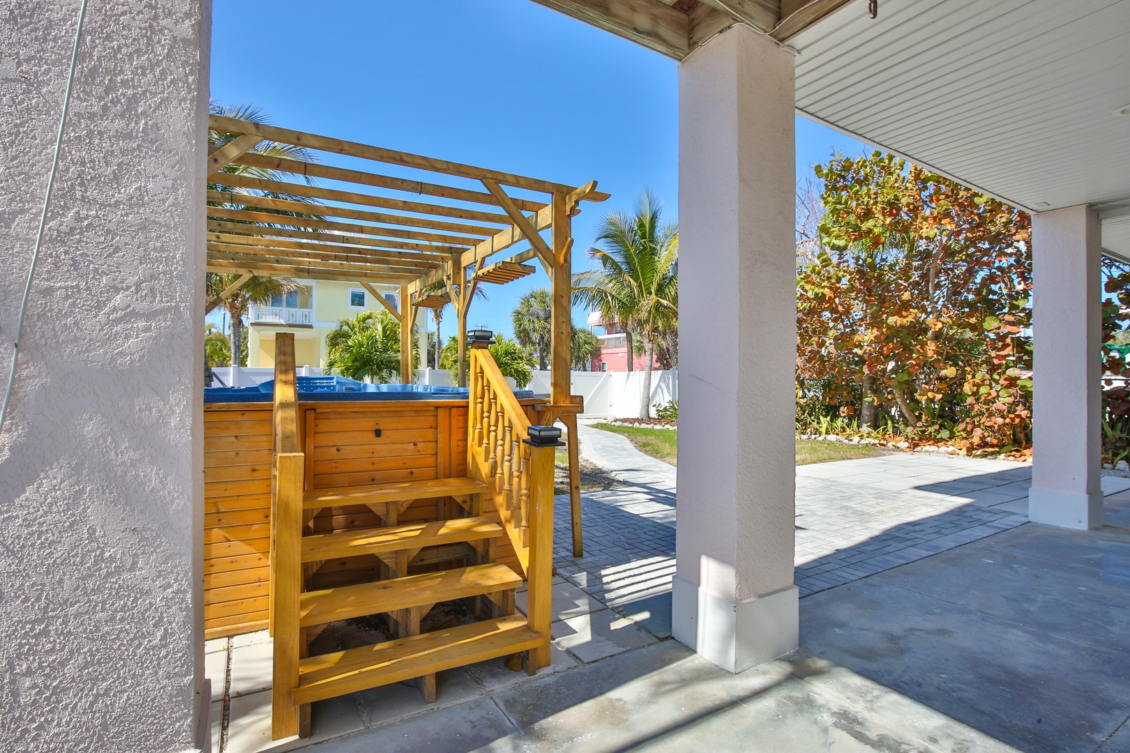 Step into your private oasis where the hot tub awaits under tropical blue skies and swaying palms.
