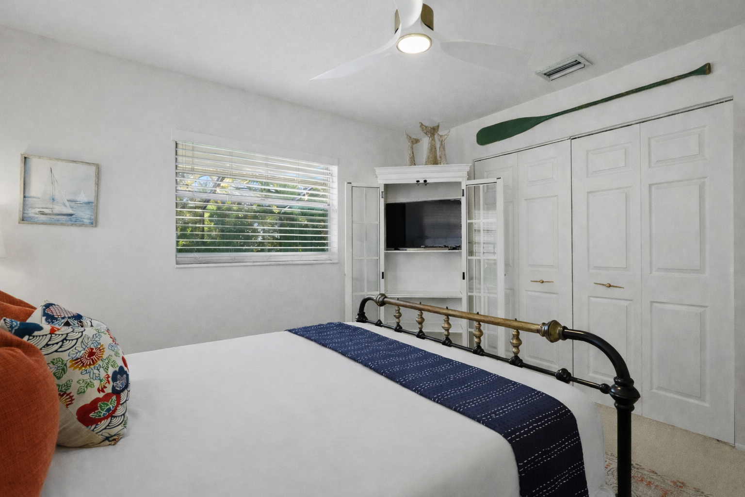 Your nautical-themed bedroom features crisp linens, charming coastal decor, and convenient entertainment tucked into custom cabinetry for relaxing evenings.