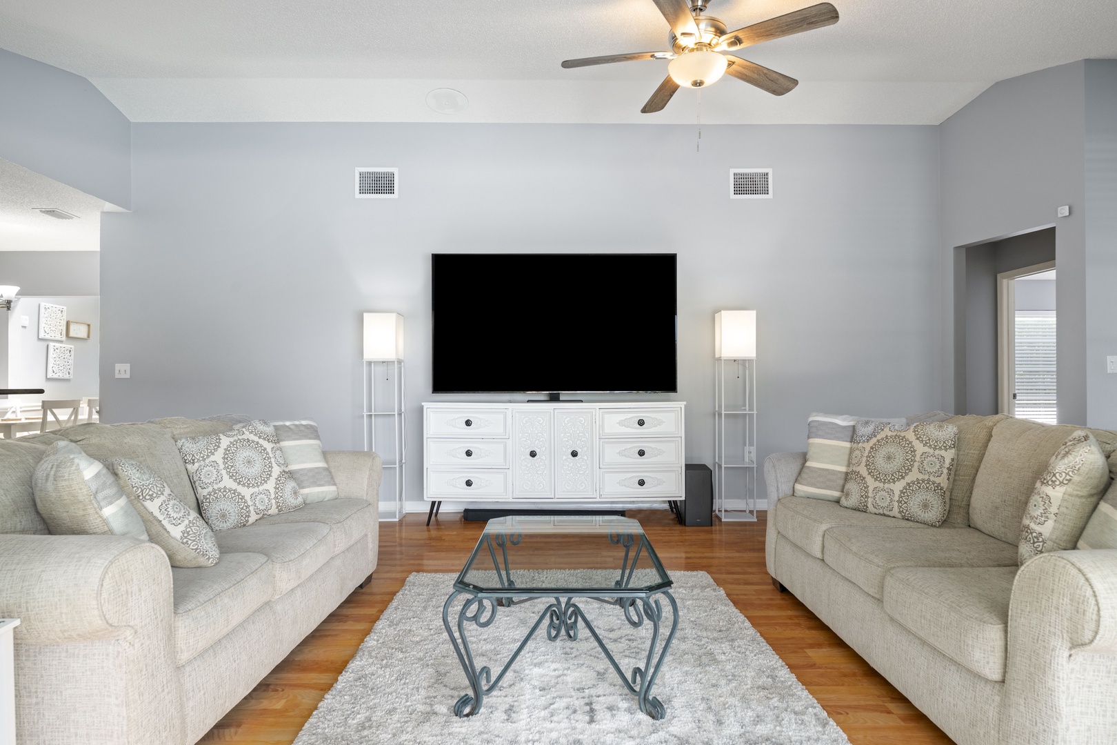 Sink into plush sofas and gather for movie nights or conversations in your bright, airy living space. Warm wood floors and ample seating invite you to relax and unwind together.