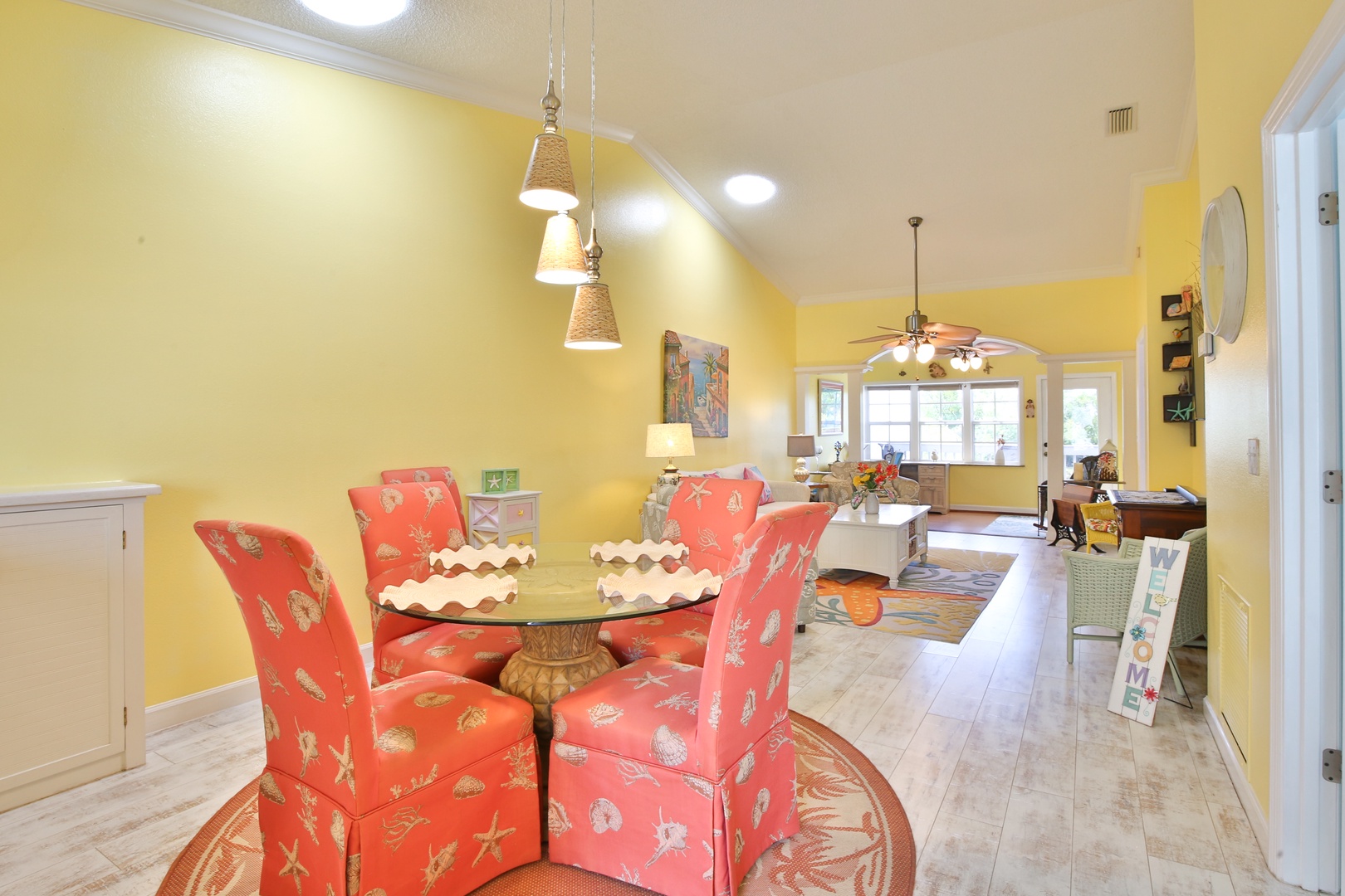 Gather around this cheerful dining space, where vibrant coral chairs and warm yellow walls create the perfect setting for your morning coffee or evening meals together.
