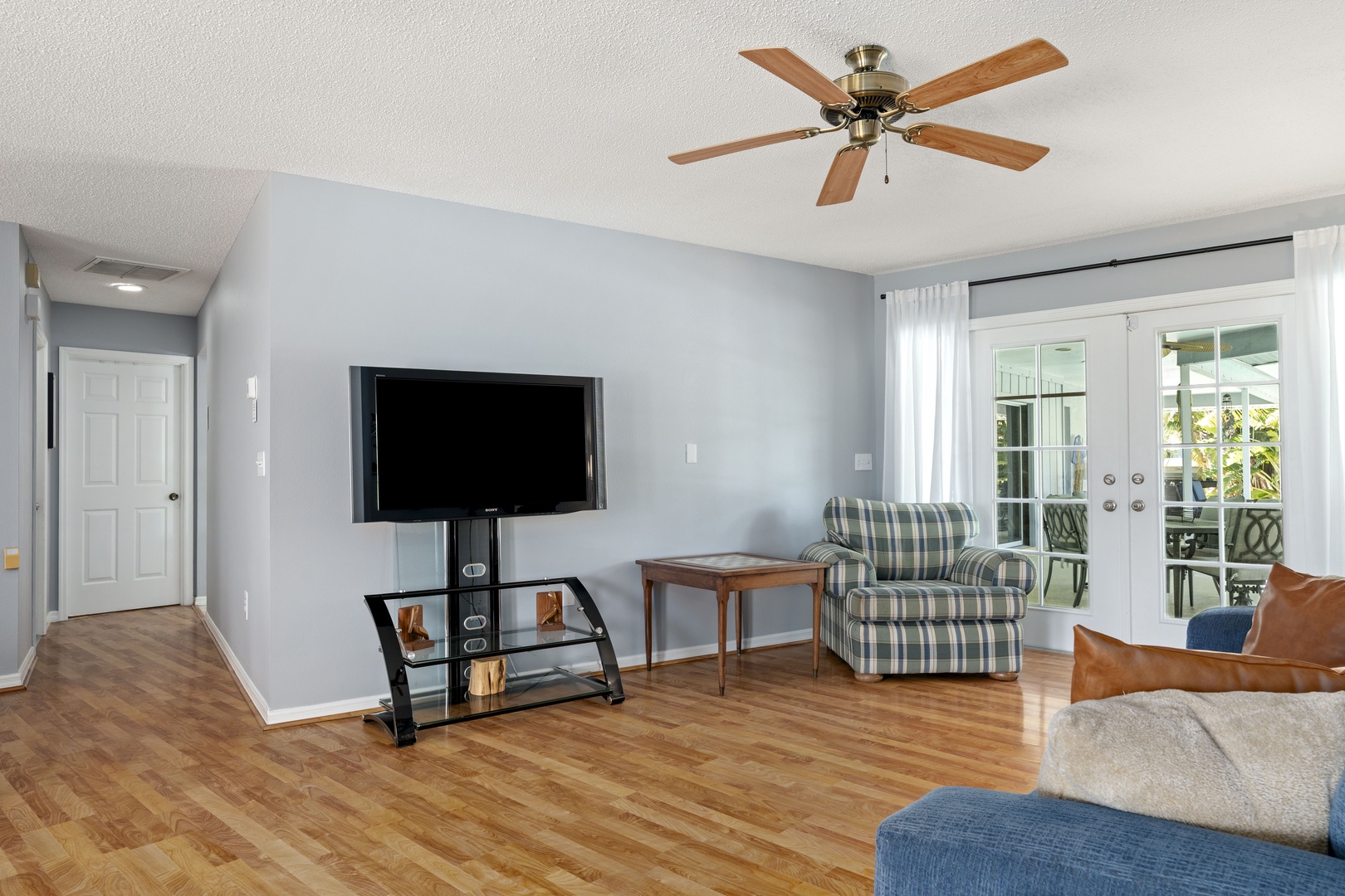 Relax in your light-filled living room where coastal breezes flow through French doors leading to your private outdoor retreat. The open layout and ceiling fan keep you comfortable year-round.