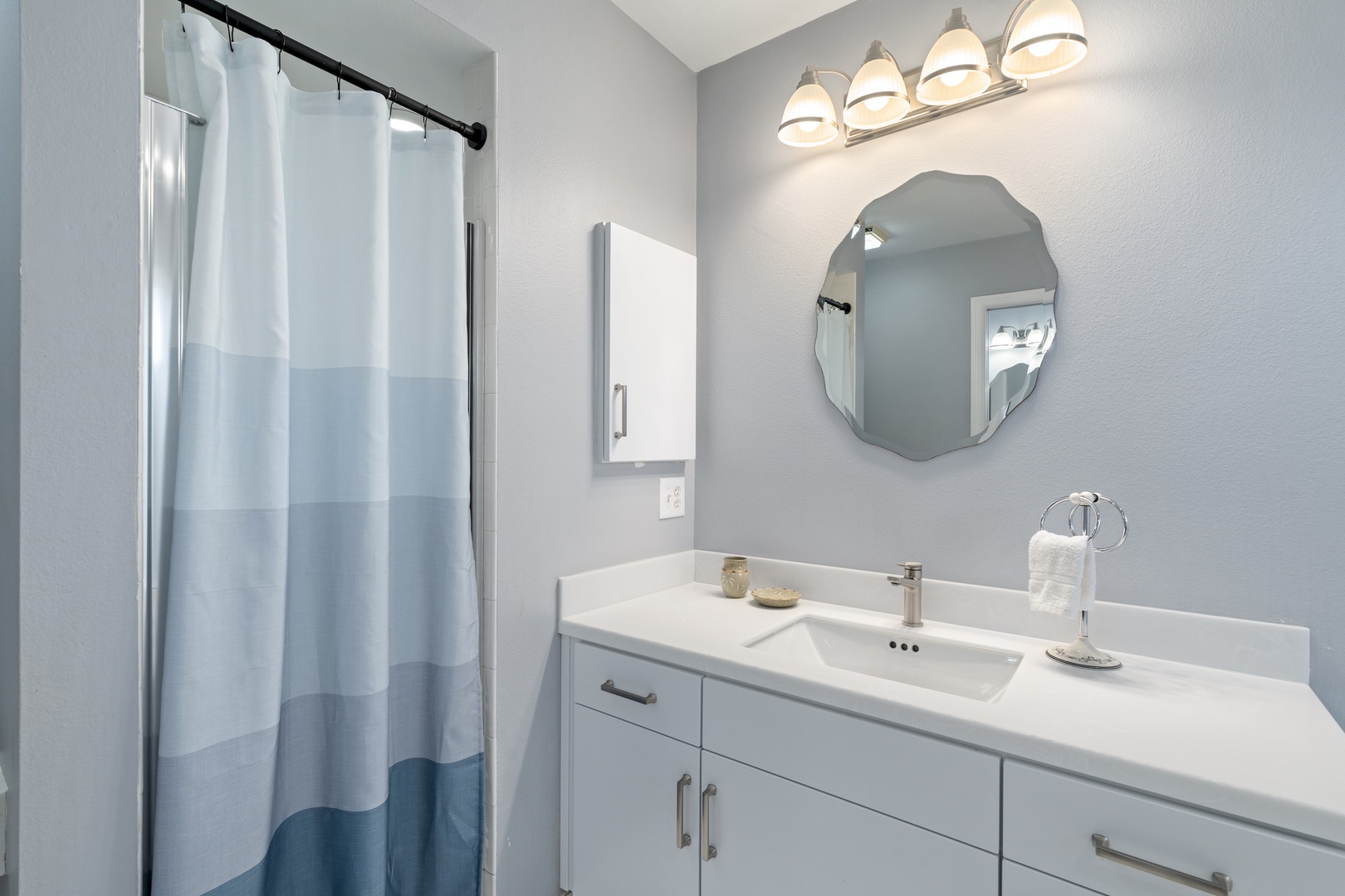 Refresh in your own serene spa-like bathroom, where soft blue-gray tones and modern touches create a calming retreat after a day of exploring.