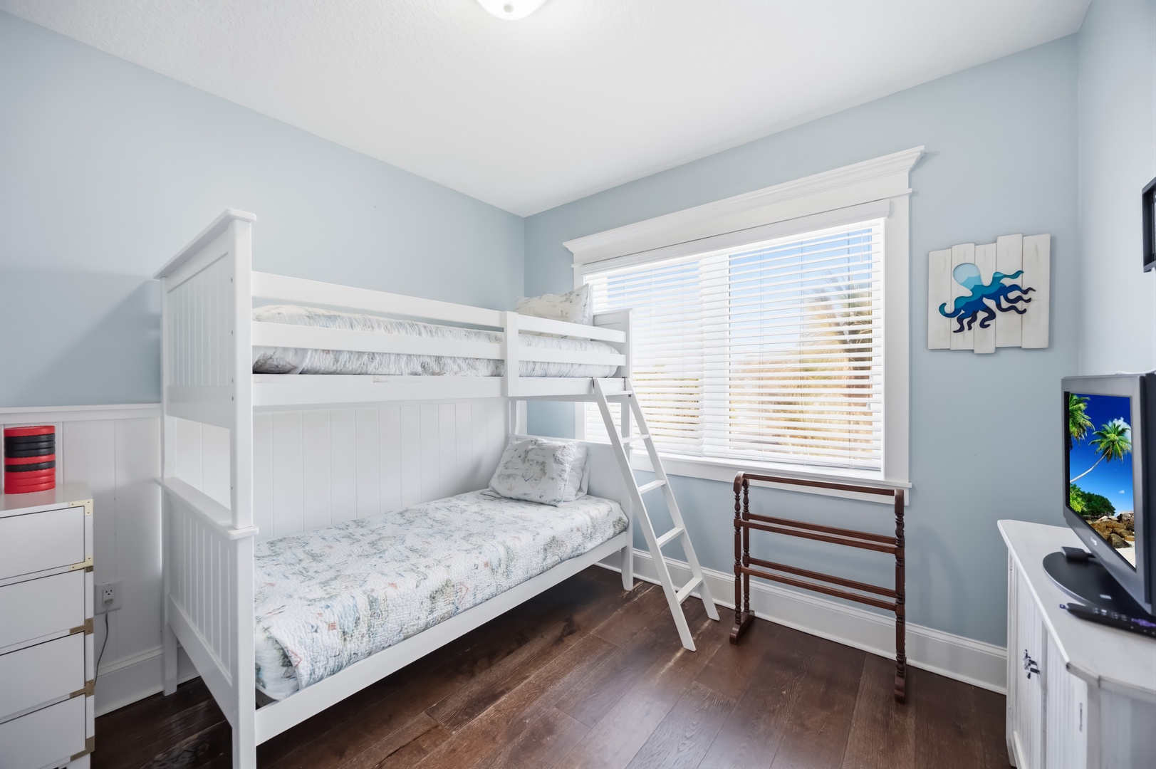 Your kids will love this cheerful bunk room with ocean-themed artwork and plenty of space for adventures.