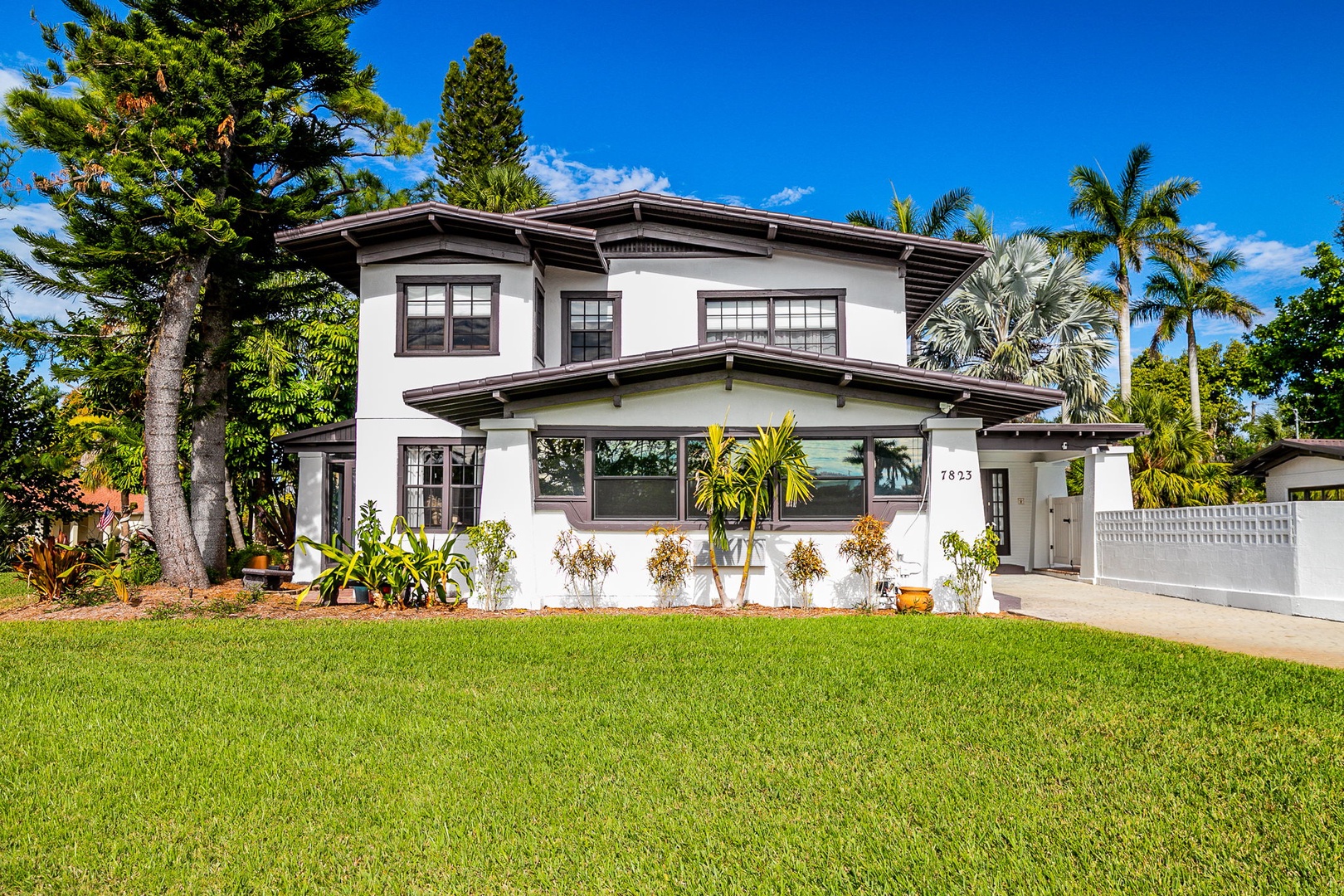 Tropical vacation home featuring spacious layout with lush garden setting and mature palm trees providing natural shade.
