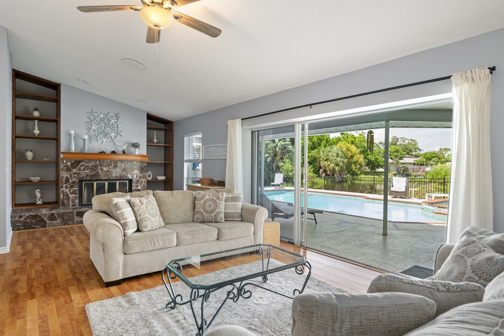Sink into plush seating and enjoy your private pool right outside the sliding doors. Natural light floods this cozy space, making it the perfect retreat after a sunny day outdoors.