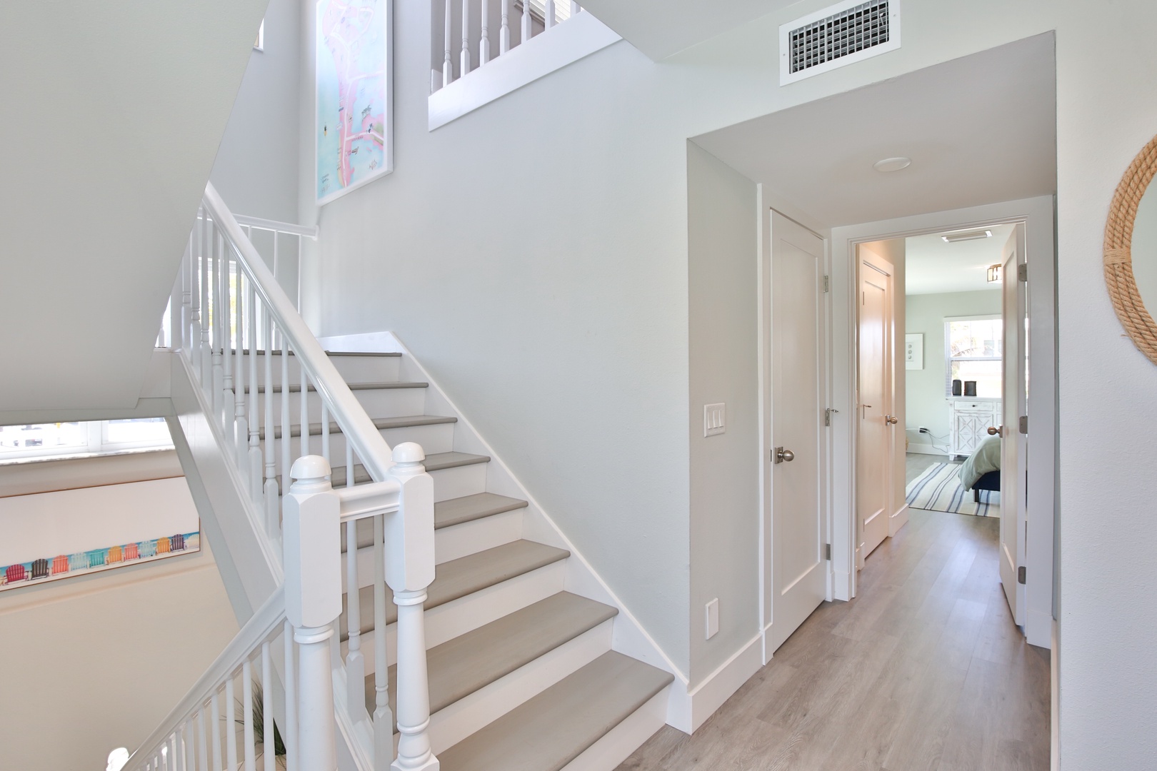Step into your bright, airy home where modern comfort meets coastal charm through crisp white stairways and open-concept design.