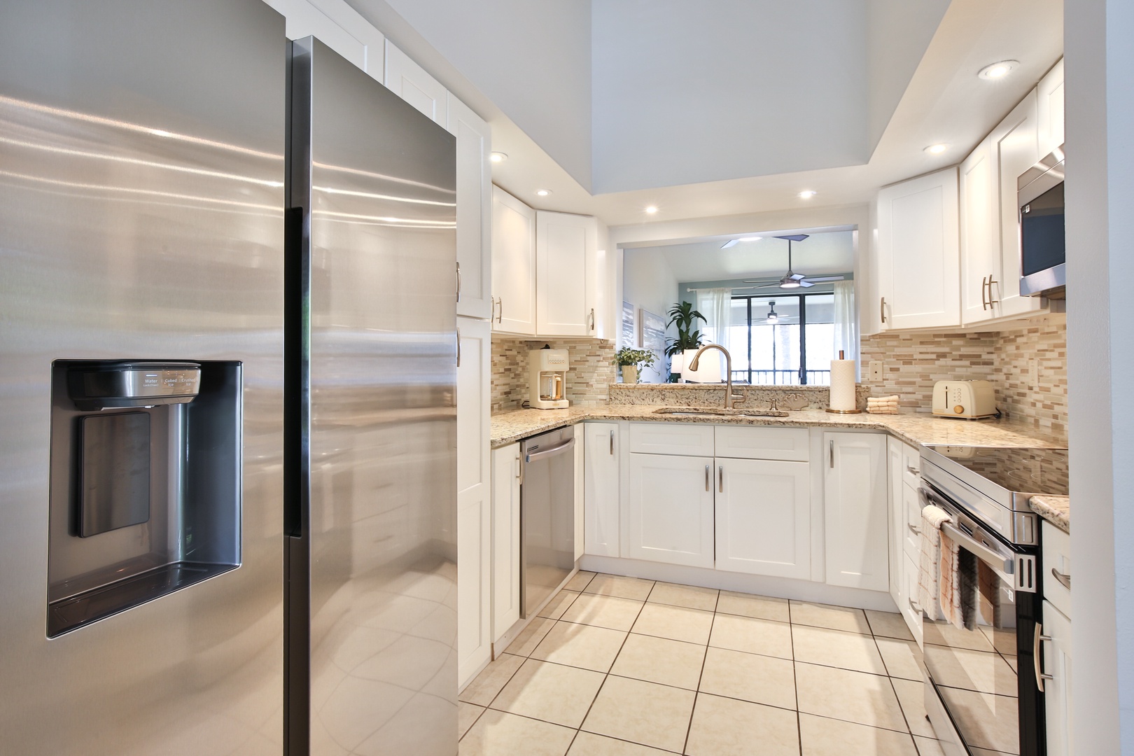 Your spacious chef's kitchen features gleaming stainless steel appliances, granite countertops, and elegant white cabinetry with beautiful tile backsplash—perfect for preparing memorable meals together.