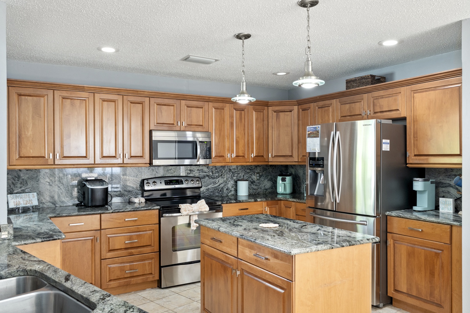 Step into your spacious, fully-equipped kitchen with ample counter space, stainless steel appliances, and a generous center island—perfect for gathering and preparing your favorite vacation meals together.
