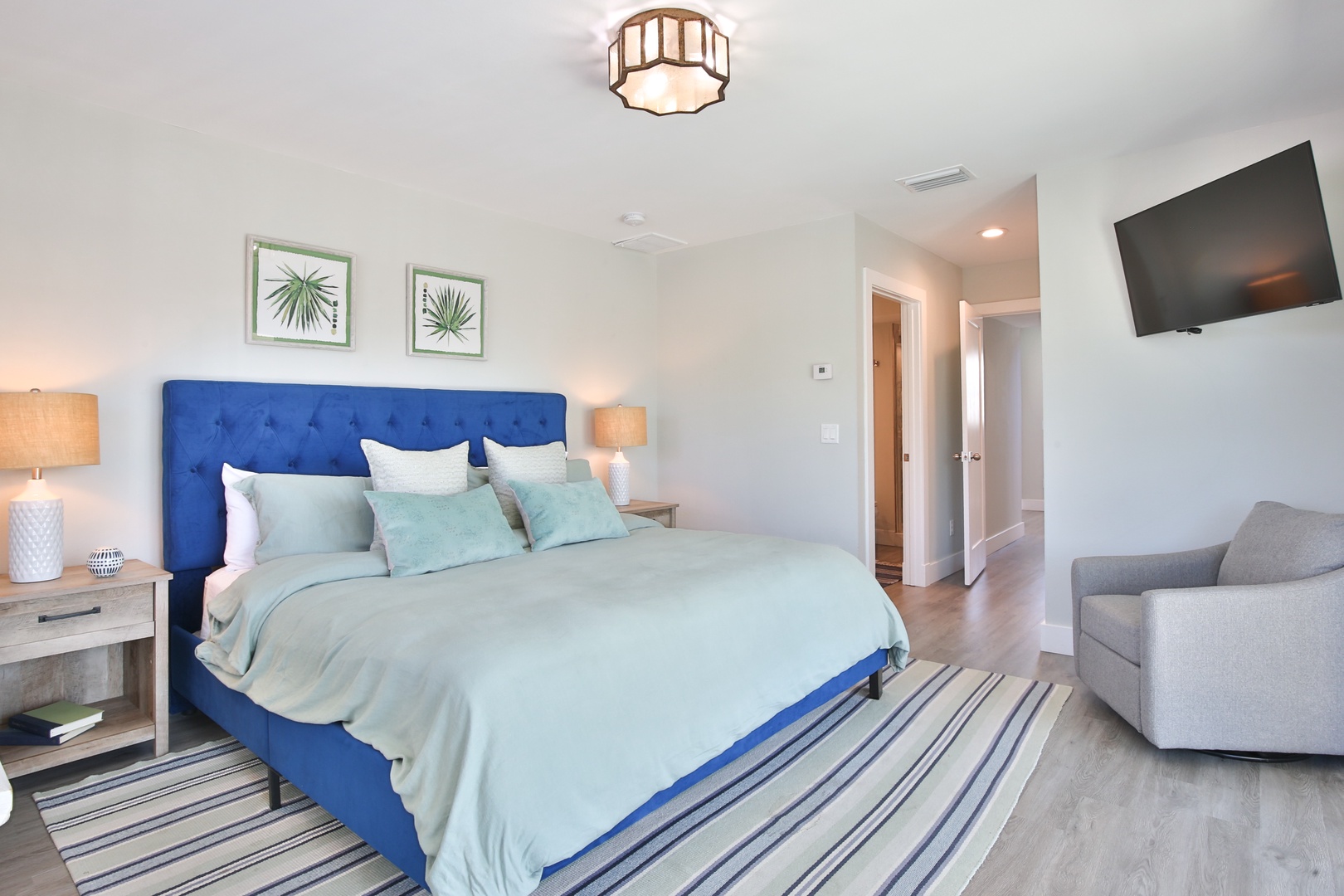 Sink into this plush blue headboard with crisp linens while enjoying your private TV and cozy seating area.